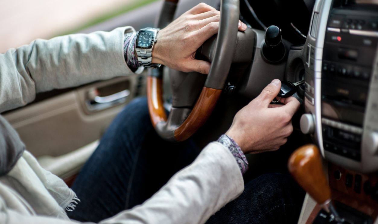 The human hand starts a car engine in car