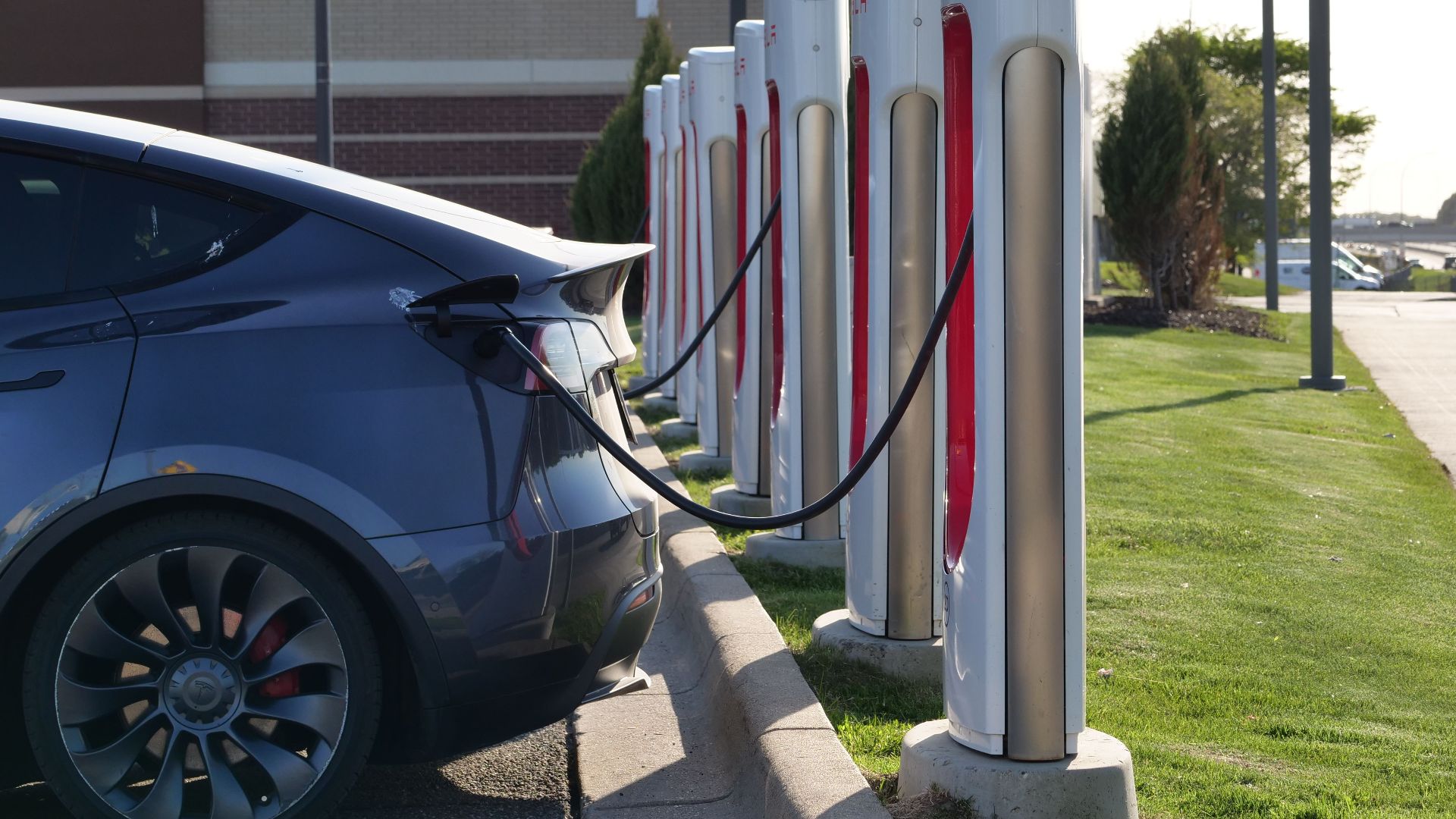 Electric car plugged into a row of charging stations, showcasing modern EV infrastructure.