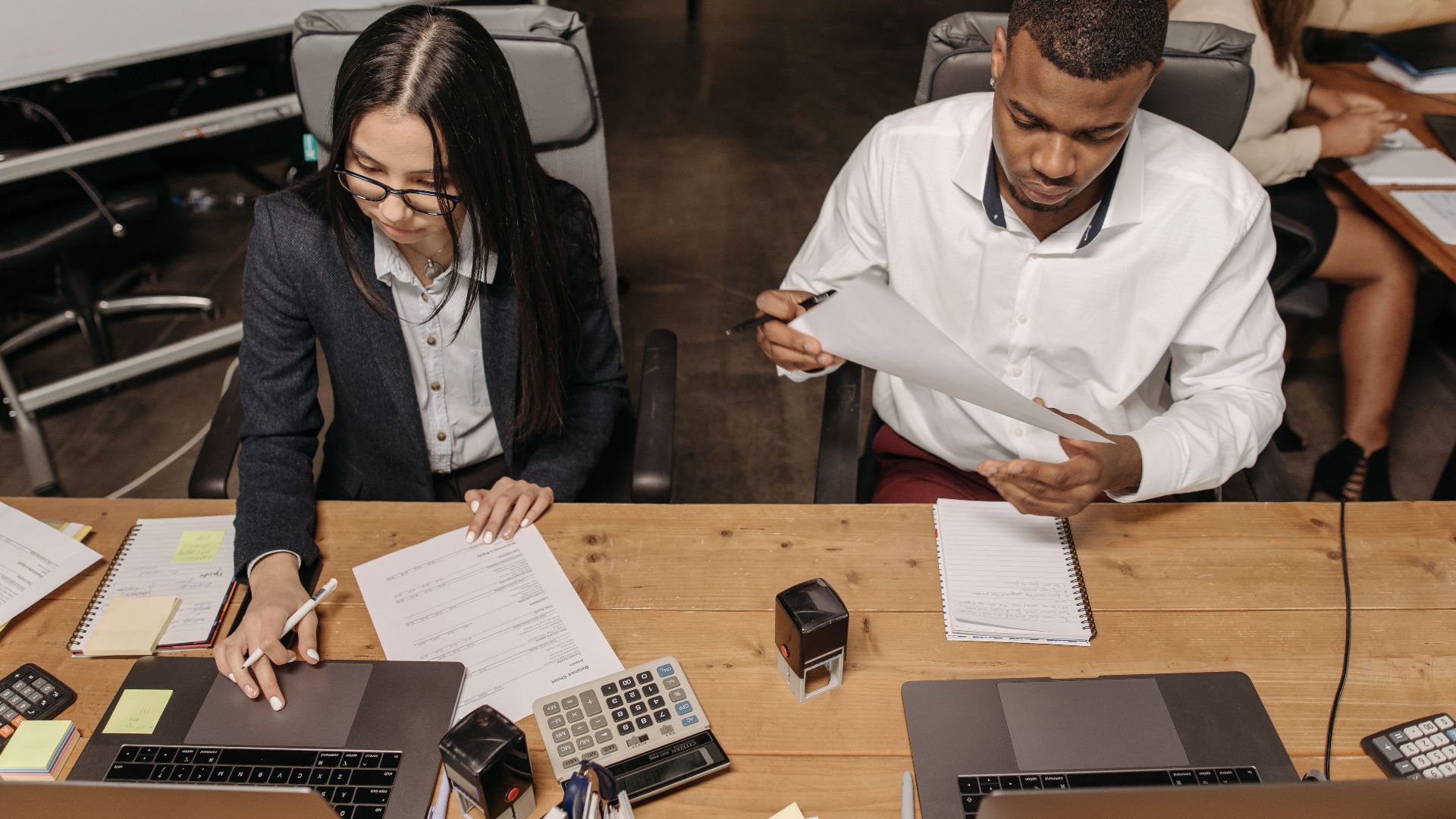 Multiracial office team working on financial documents, highlighting teamwork and productivity.