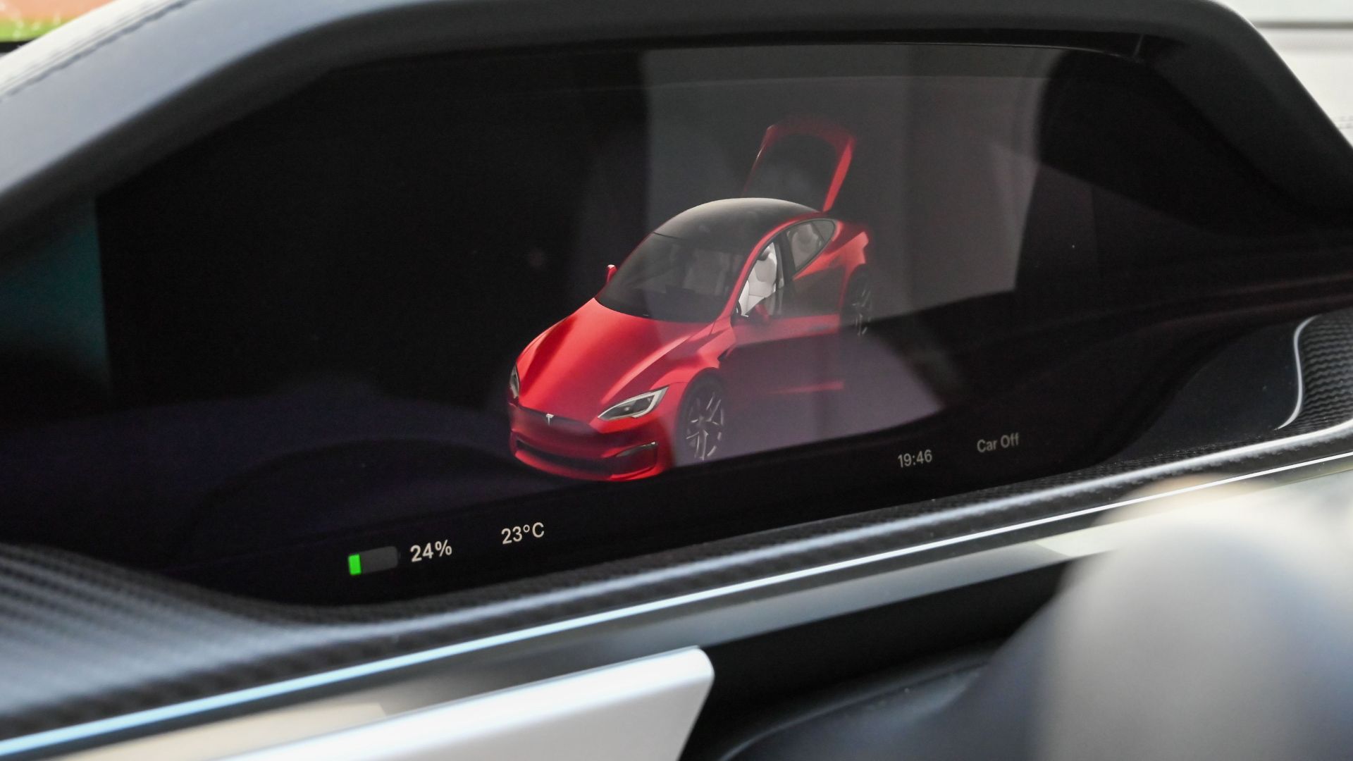 Close-up of a Tesla's dashboard showing the car's status on a digital screen.