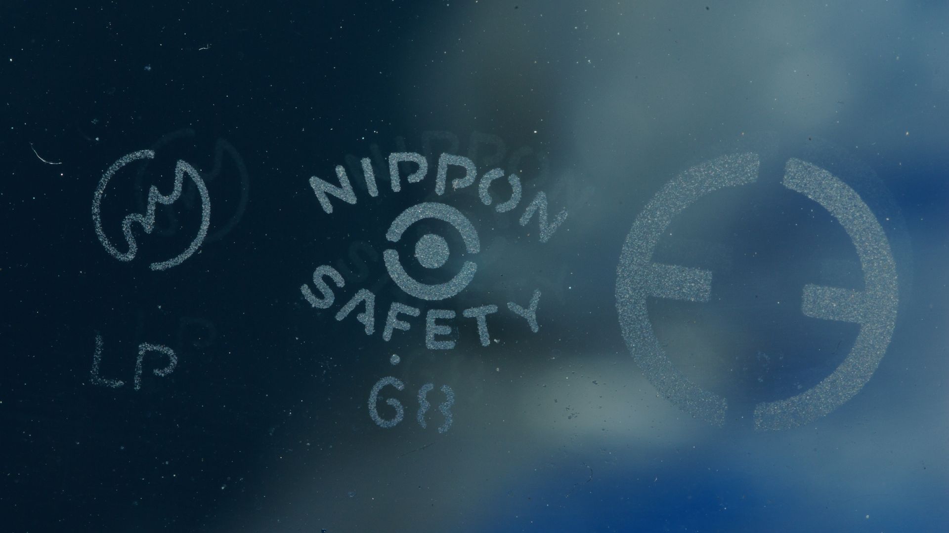 The carved seal of the windshield of Mazda, T600-type for 1,968 years. It is a logo of Toyo Kogyo, a logo of Nippon Sheet Glass, the carved seal indicating the Japanese Industrial Standards conformity LP (laminated glass) from the right.