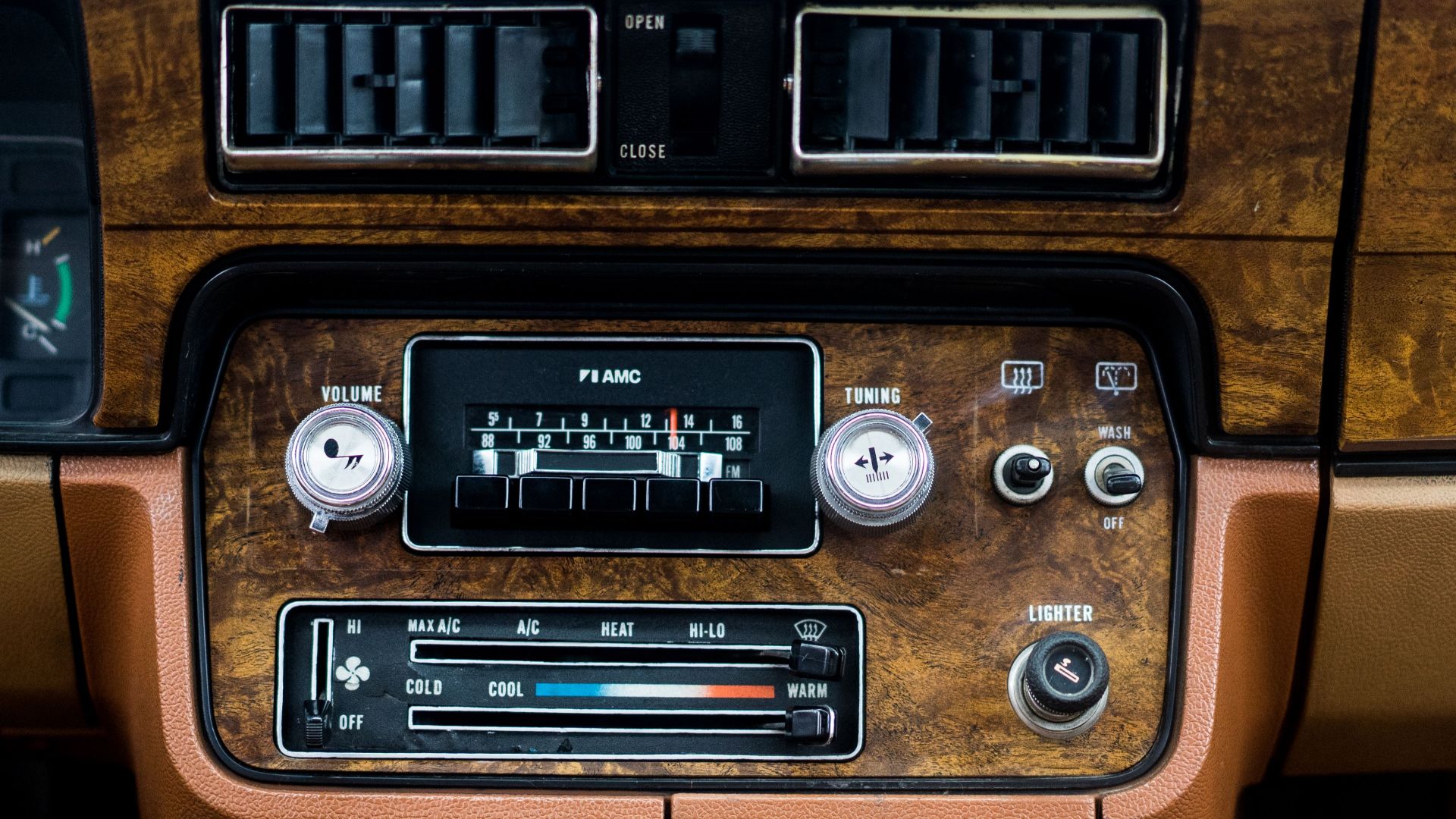 Old fashioned control dashboard with retro buttons and radio in aged brown automobile