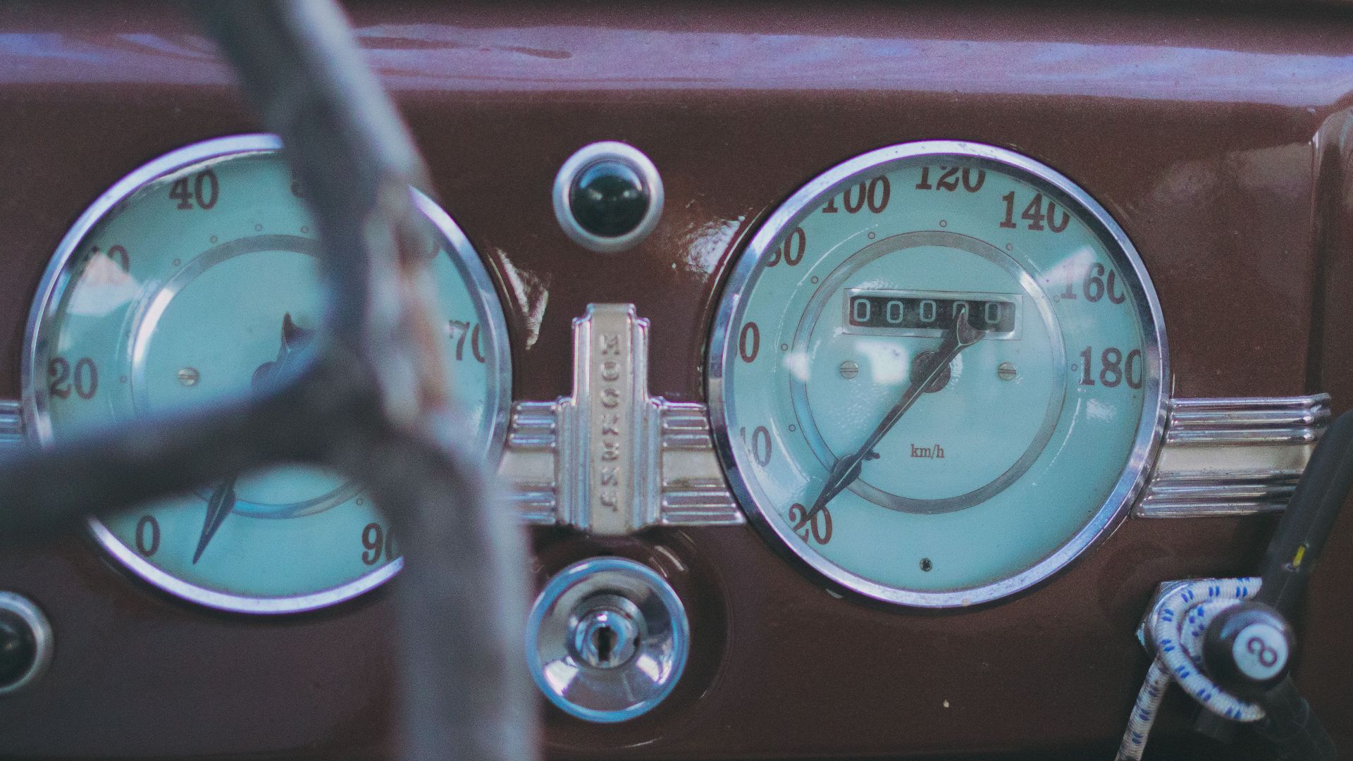 Close-up of a vintage car dashboard showing classic speedometer and odometer.