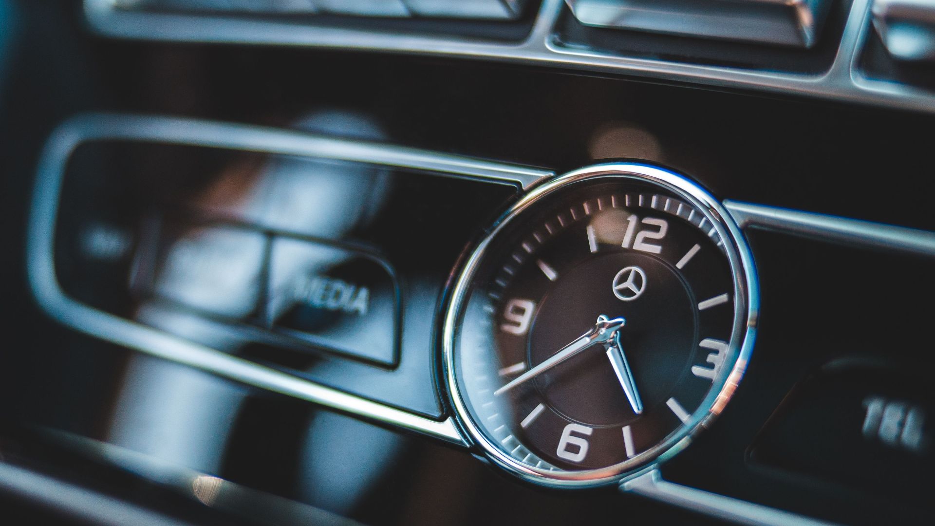 Close-up image of a luxury car dashboard clock highlighting elegant automotive design.