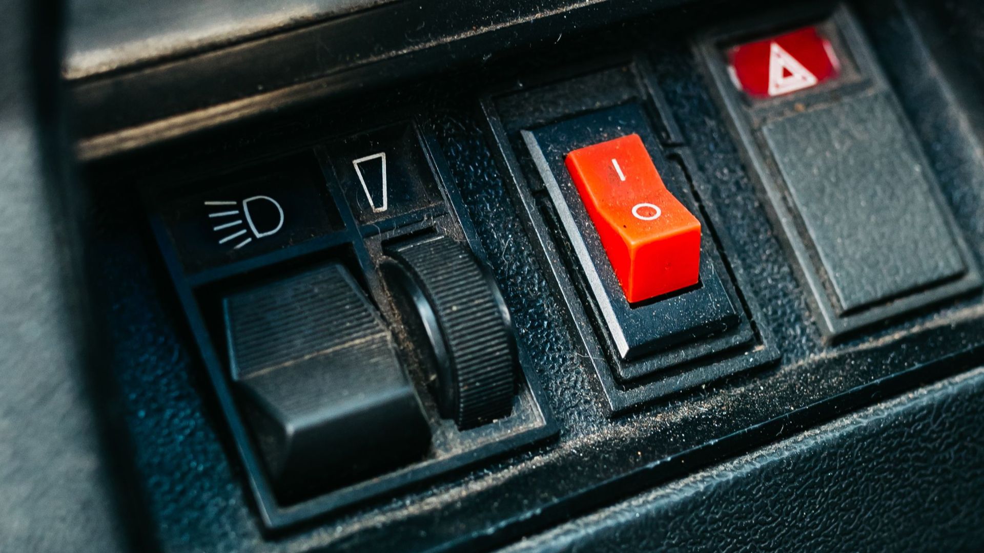 Close-up view of vintage car dashboard controls and gauges focusing on details.