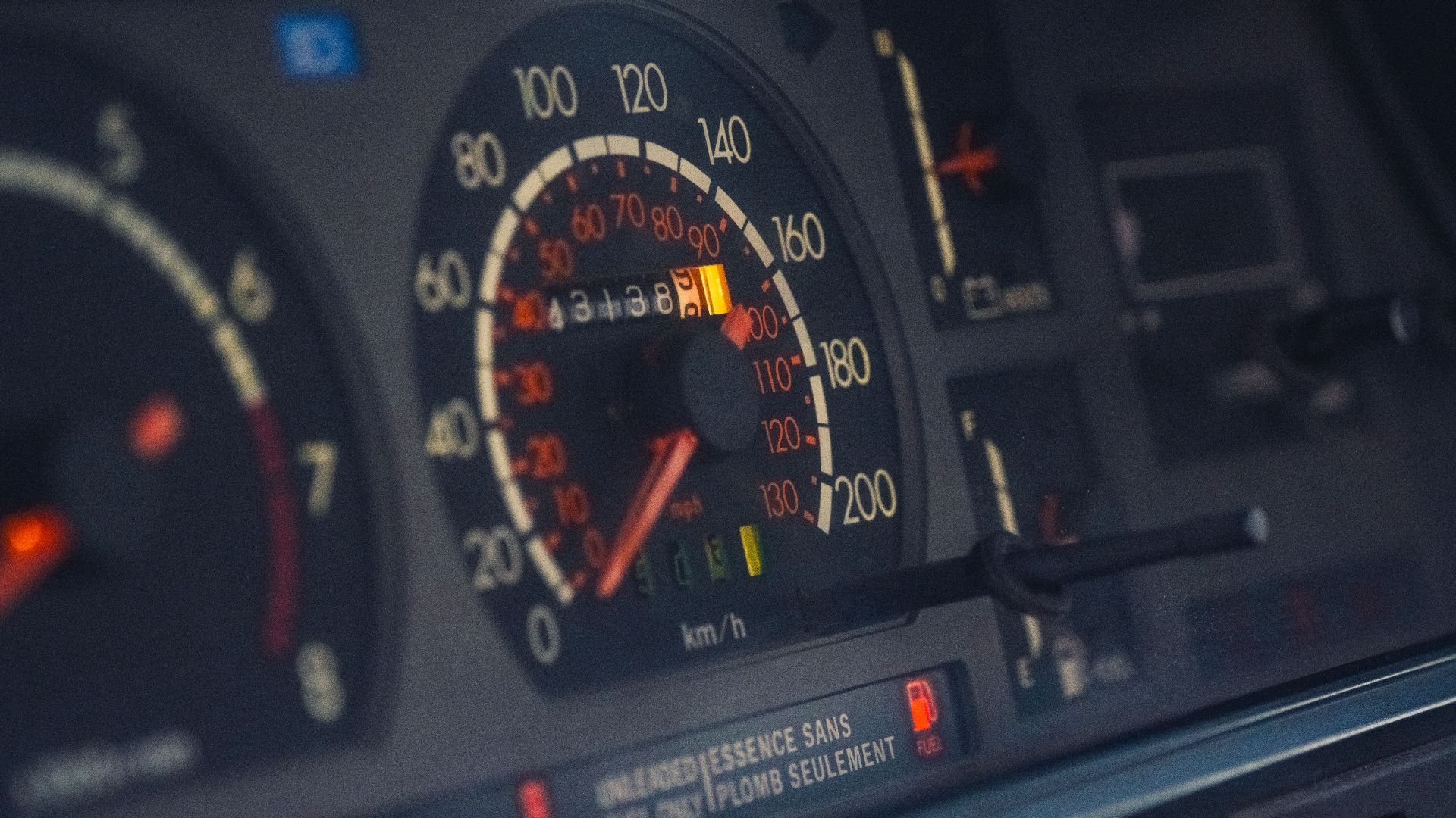Close-up of a classic car dashboard highlighting the speedometer, odometer, and instrument panel.