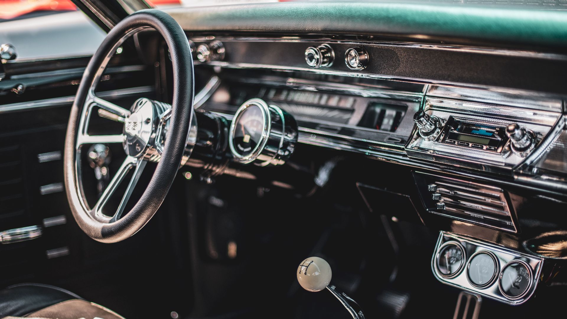 A detailed view of a classic car's interior featuring a vintage dashboard and steering wheel.