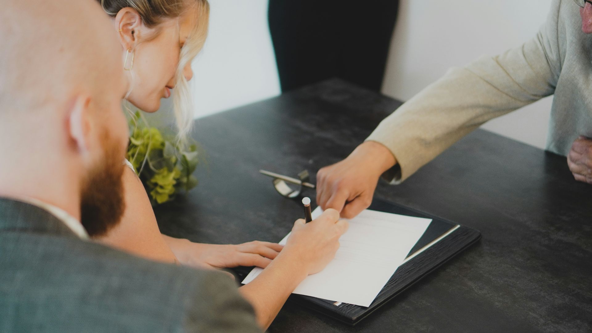 couple signing document at desk