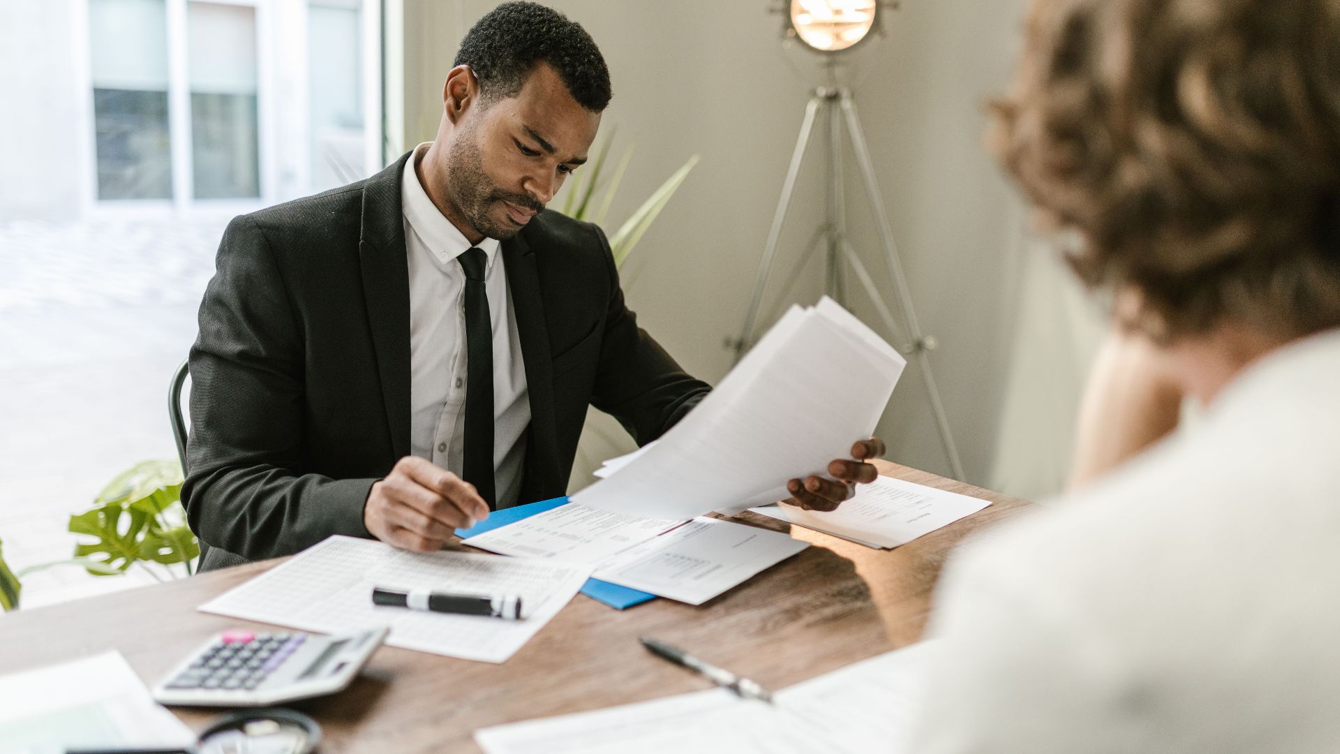 Professional businessman reviewing documents at a desk in a modern office setting.