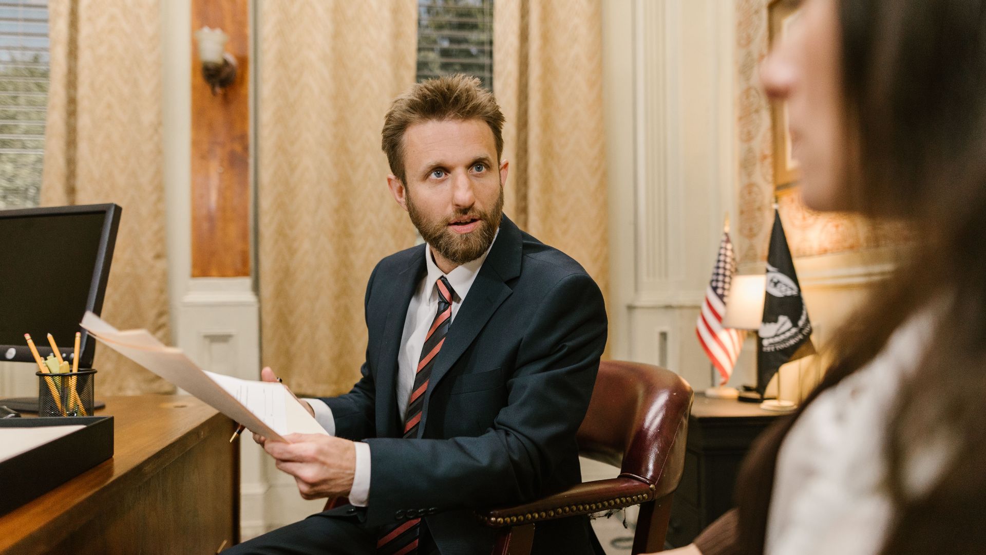 Businessman in suit discussing legal documents in office environment.