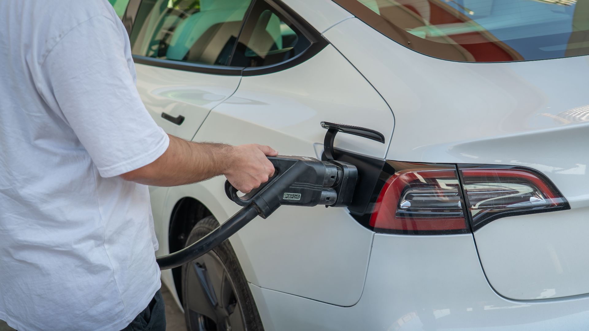 Electric car being charged at a station, highlighting eco-friendly transportation.