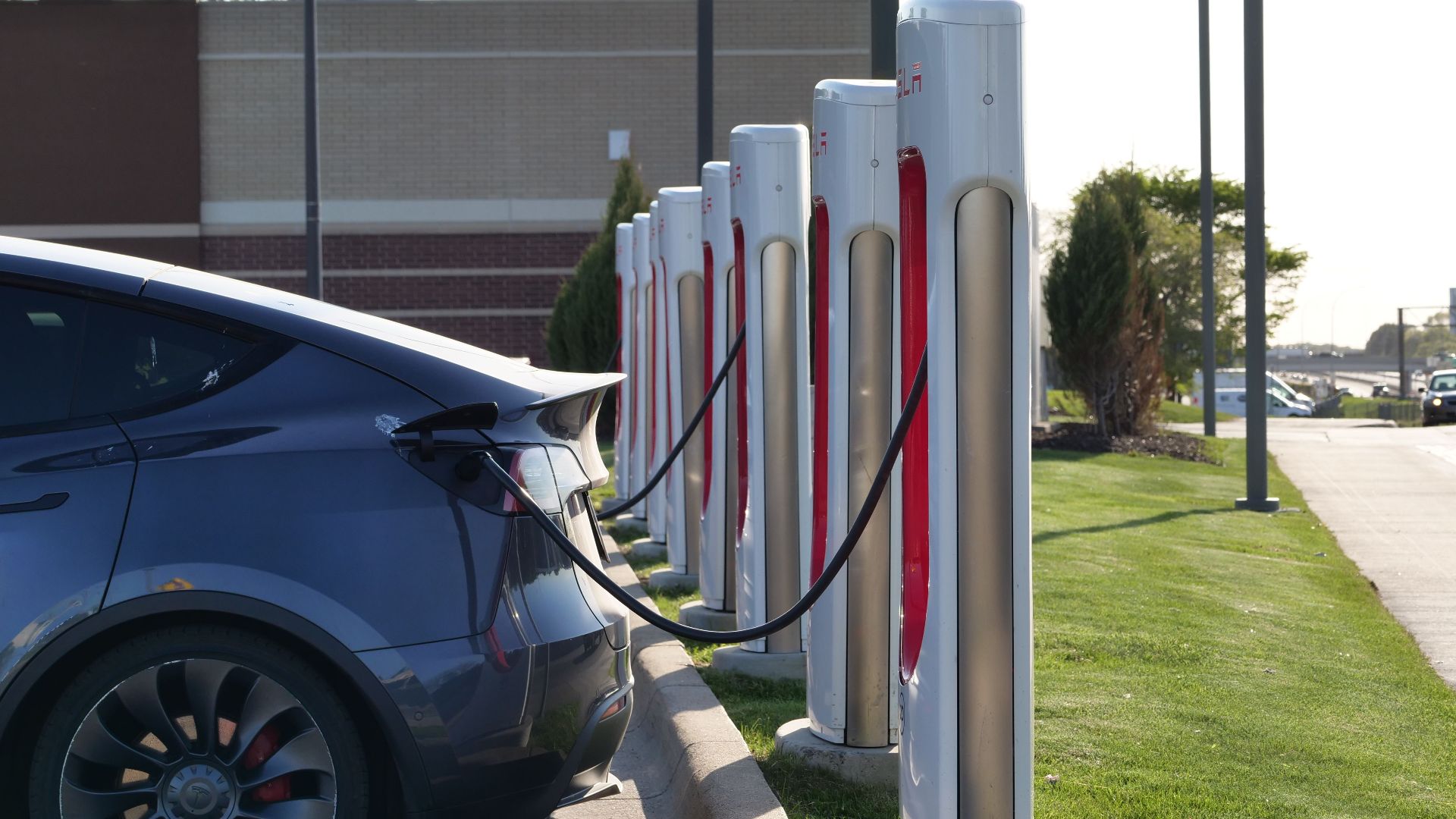 Electric car plugged into a row of charging stations, showcasing modern EV infrastructure.