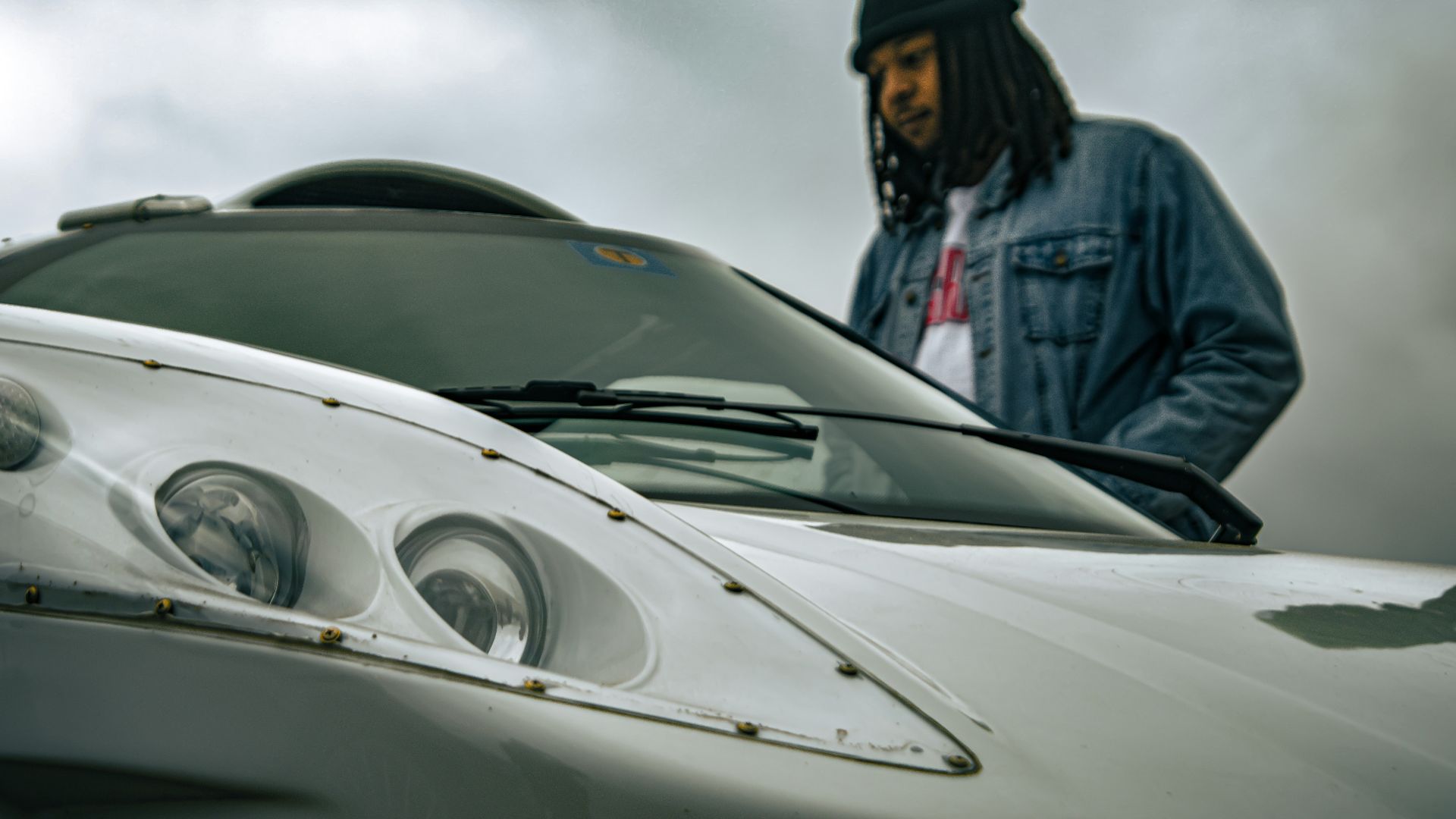 A man standing next to a white sports car