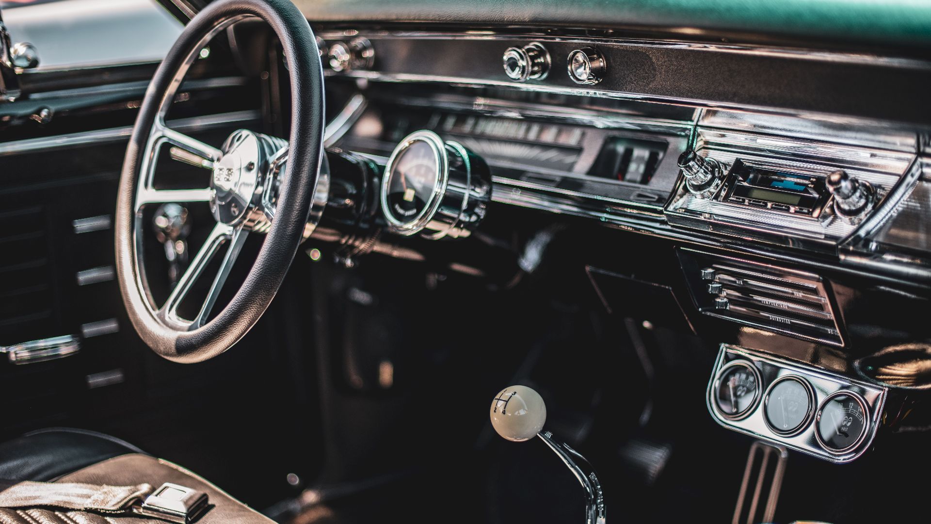 A detailed view of a classic car's interior featuring a vintage dashboard and steering wheel.