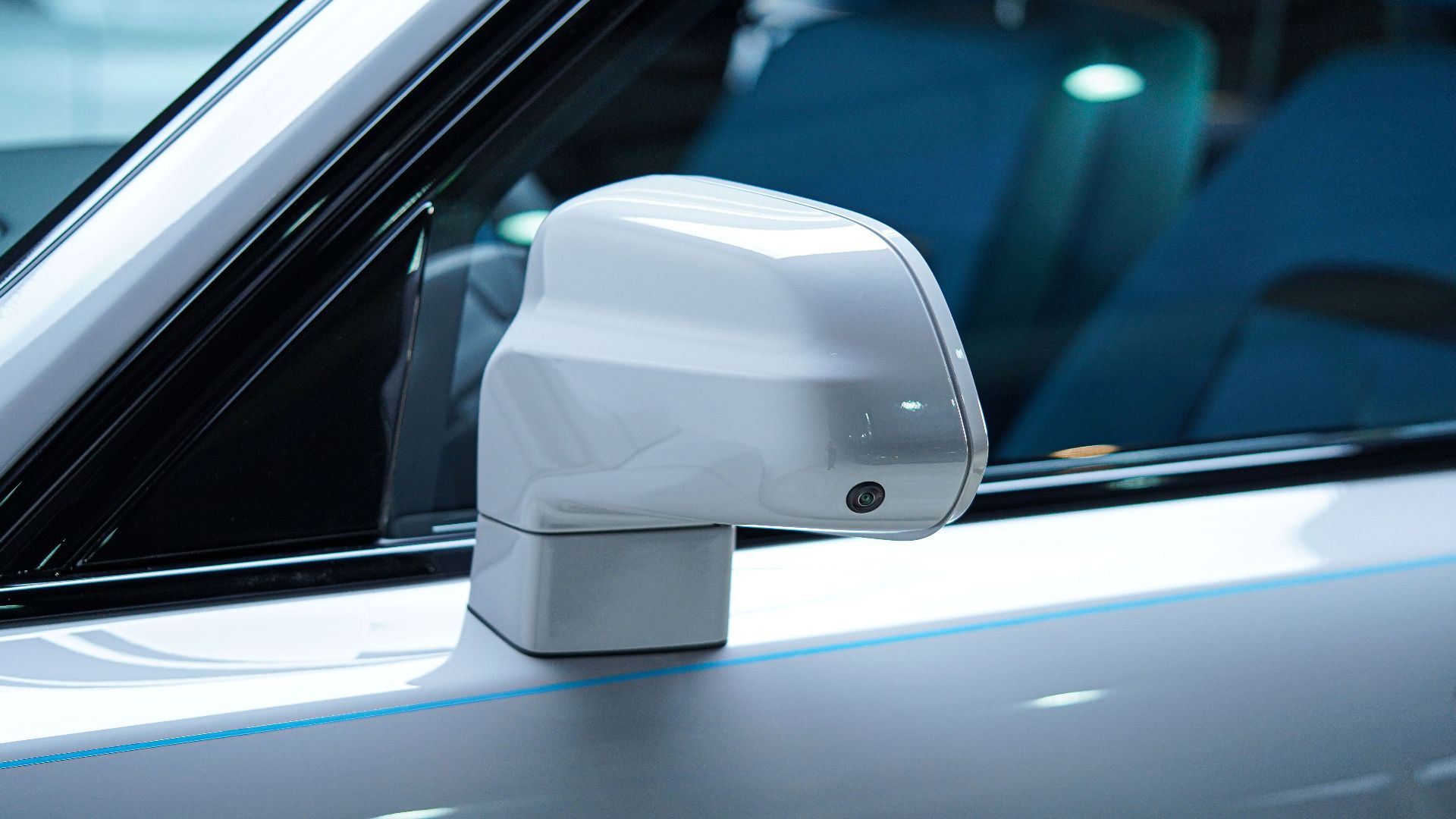 Detailed view of a sleek white car side mirror in Sulaymaniyah, Iraq, emphasizing luxury and modern design.