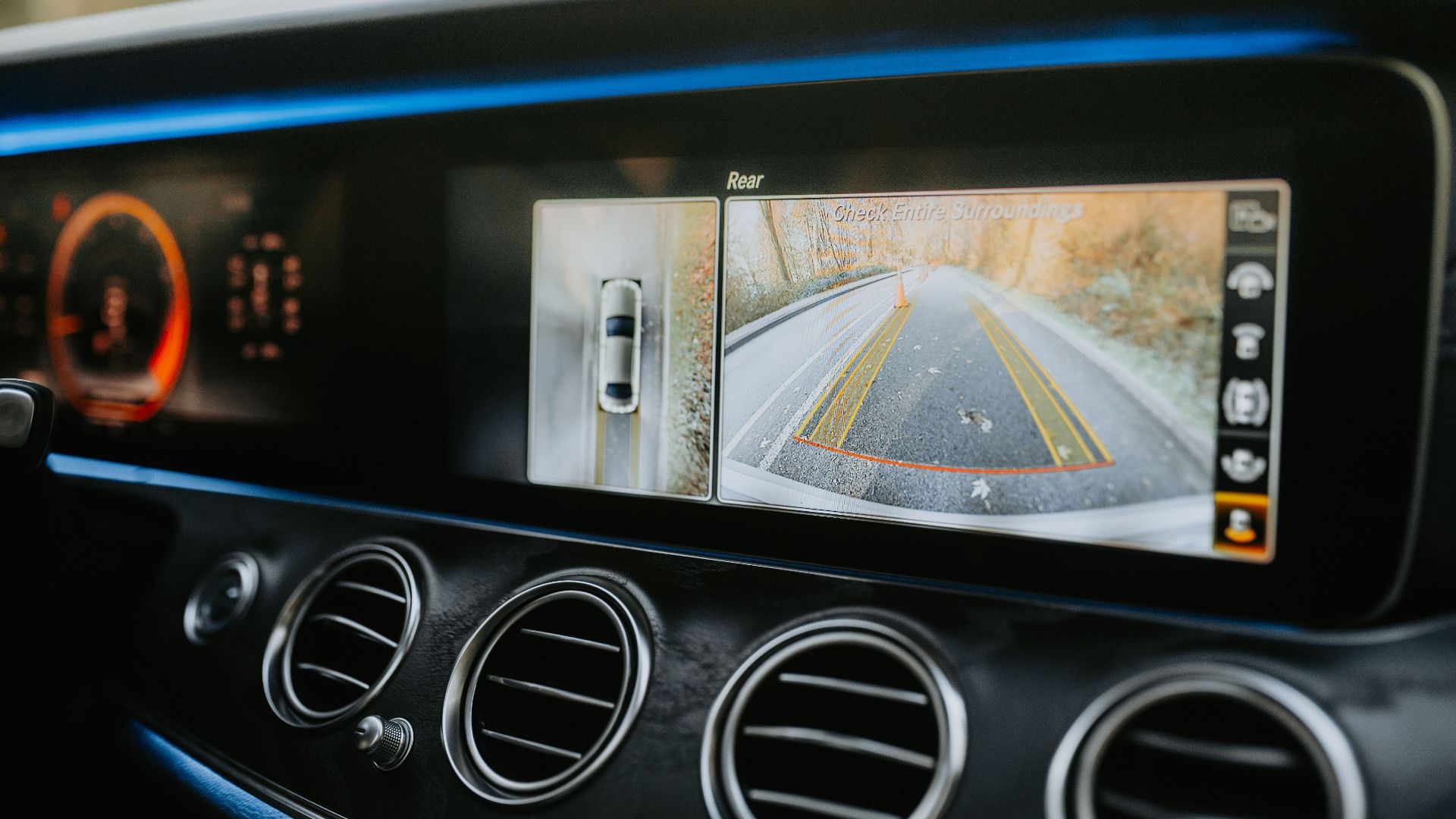 Close-up of a car dashboard showcasing a rear-view camera display and modern electronics.
