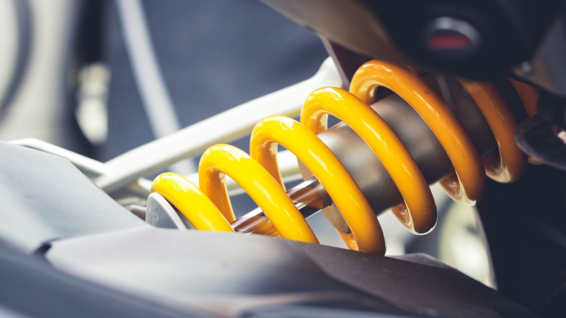 Close-up of a vibrant yellow coil spring, showcasing mechanical engineering details.