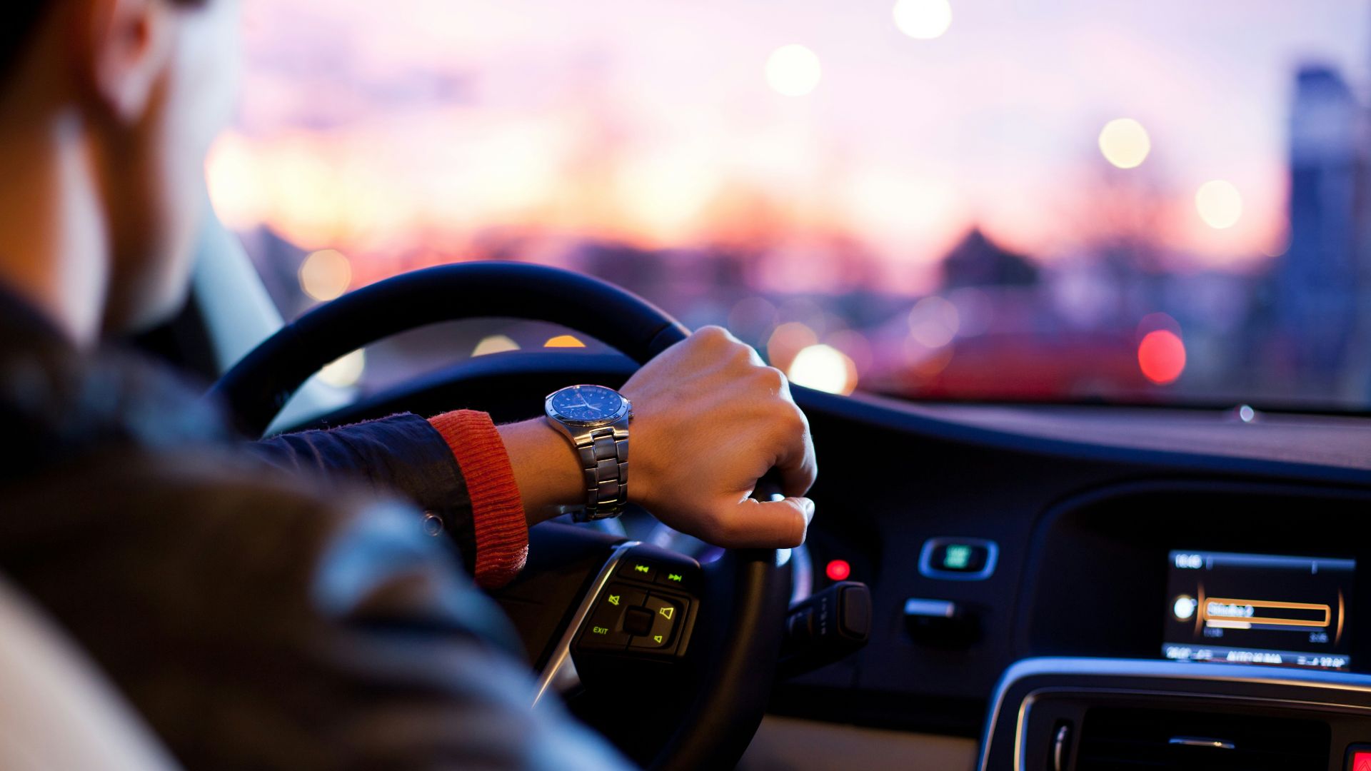 man driving a car wearing wrist watch
