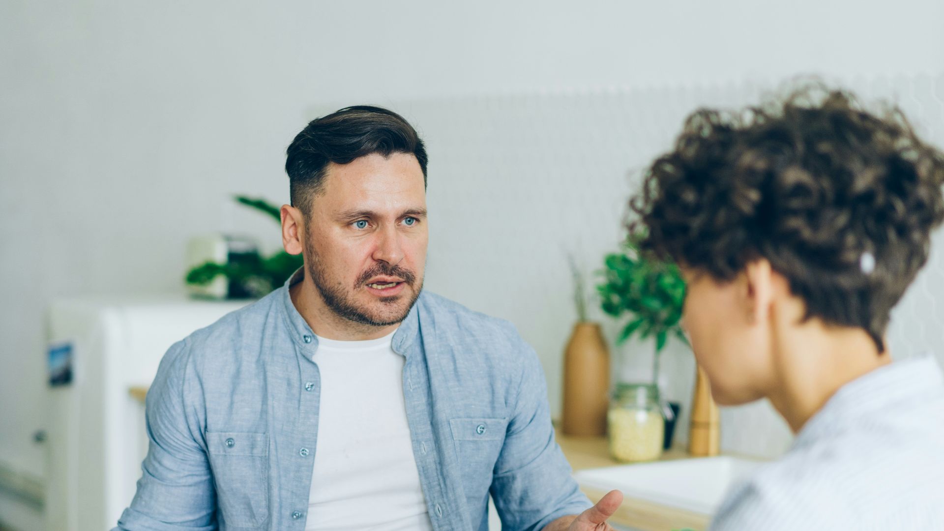 a man sitting at a table talking to a woman