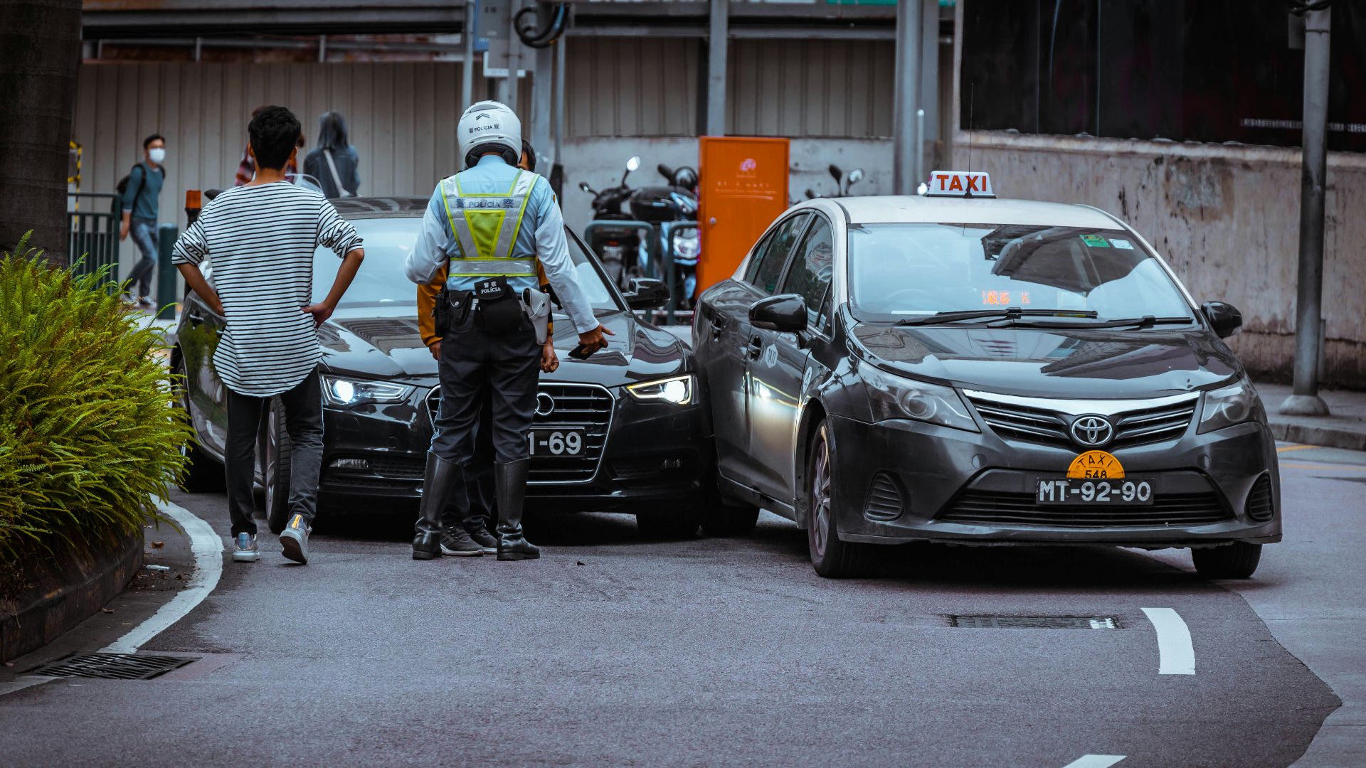 man in white and black stripe shirt and black pants standing beside black car during daytime