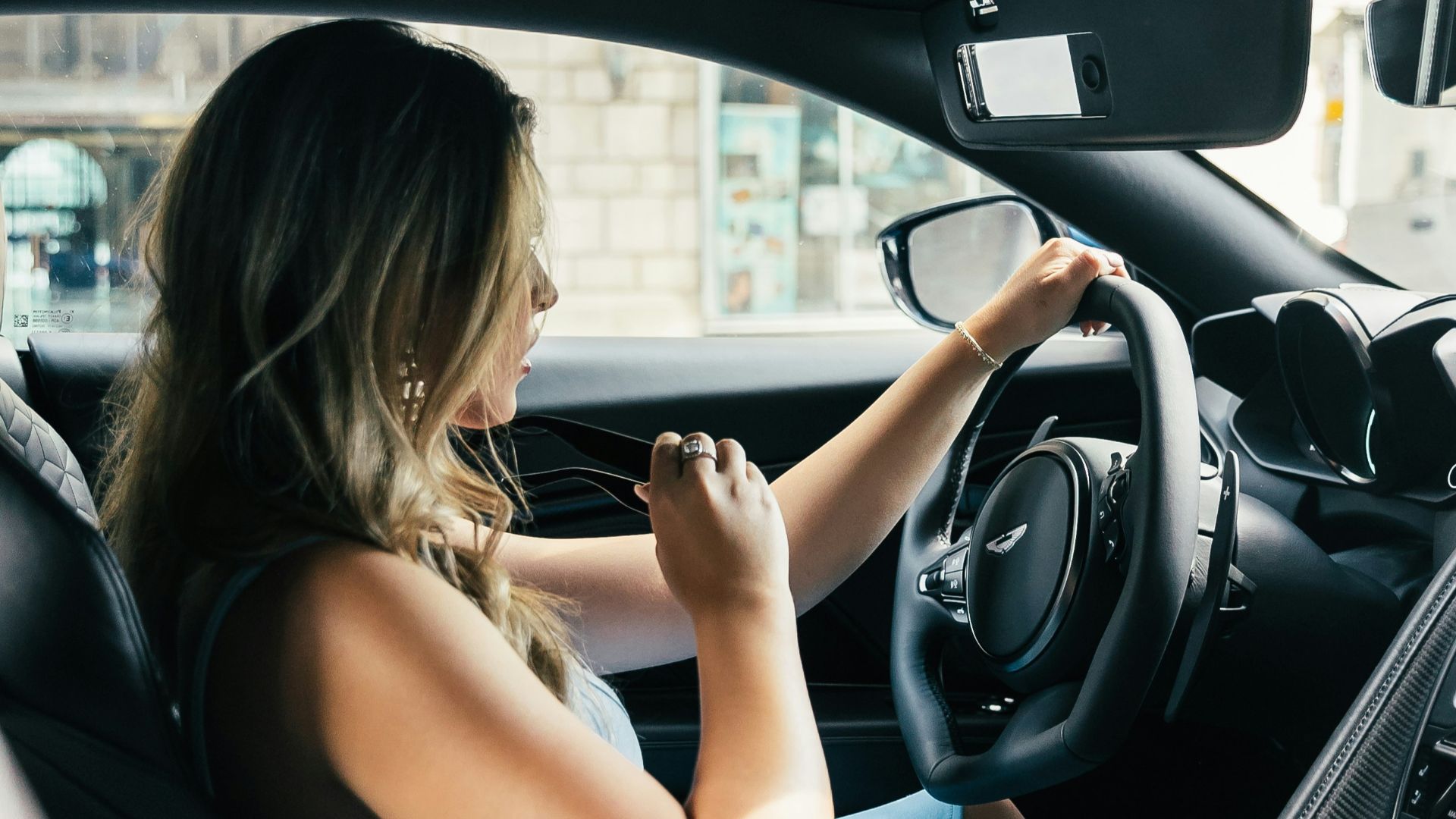 woman wearing white tank top driving vehicle during daytime