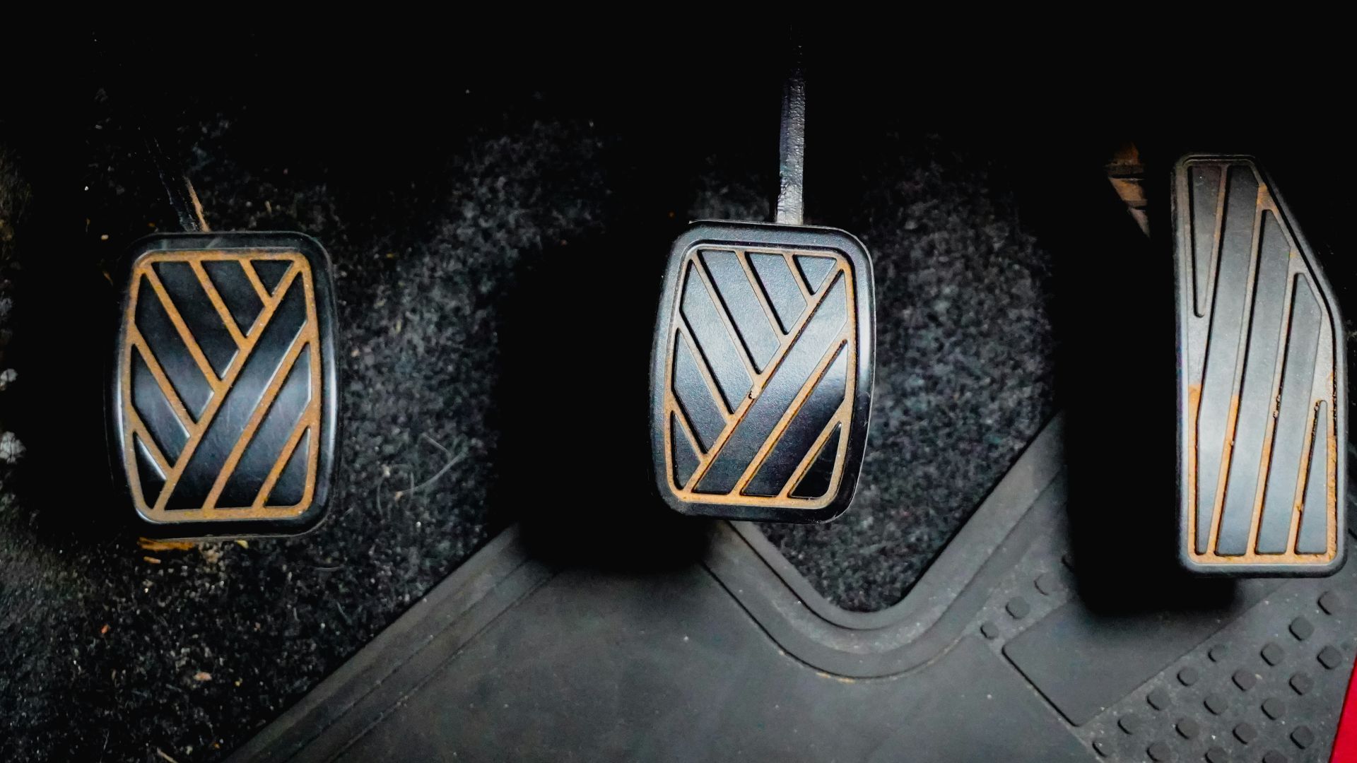 Three car pedals on the floor