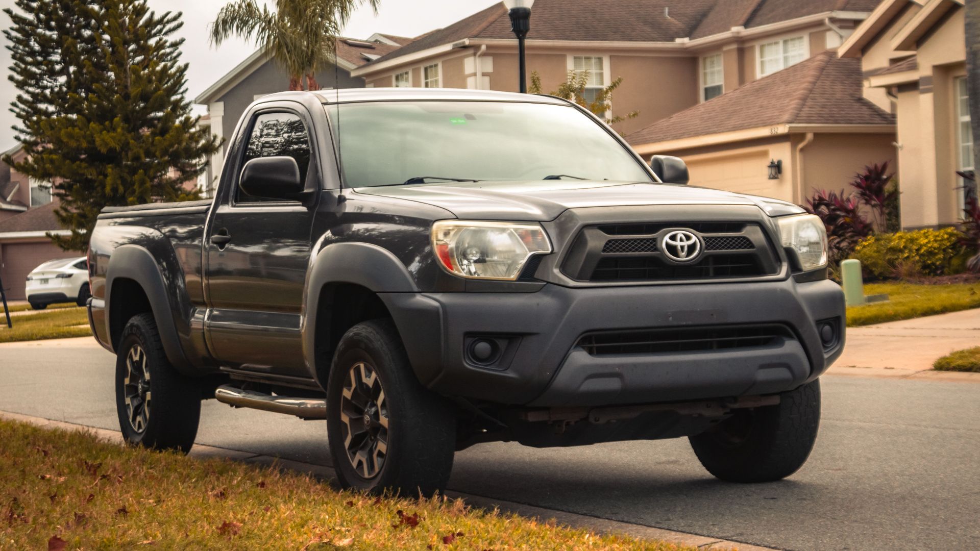 Gray Toyota Tacoma parked in a suburban neighborhood street of Winter Springs, FL.