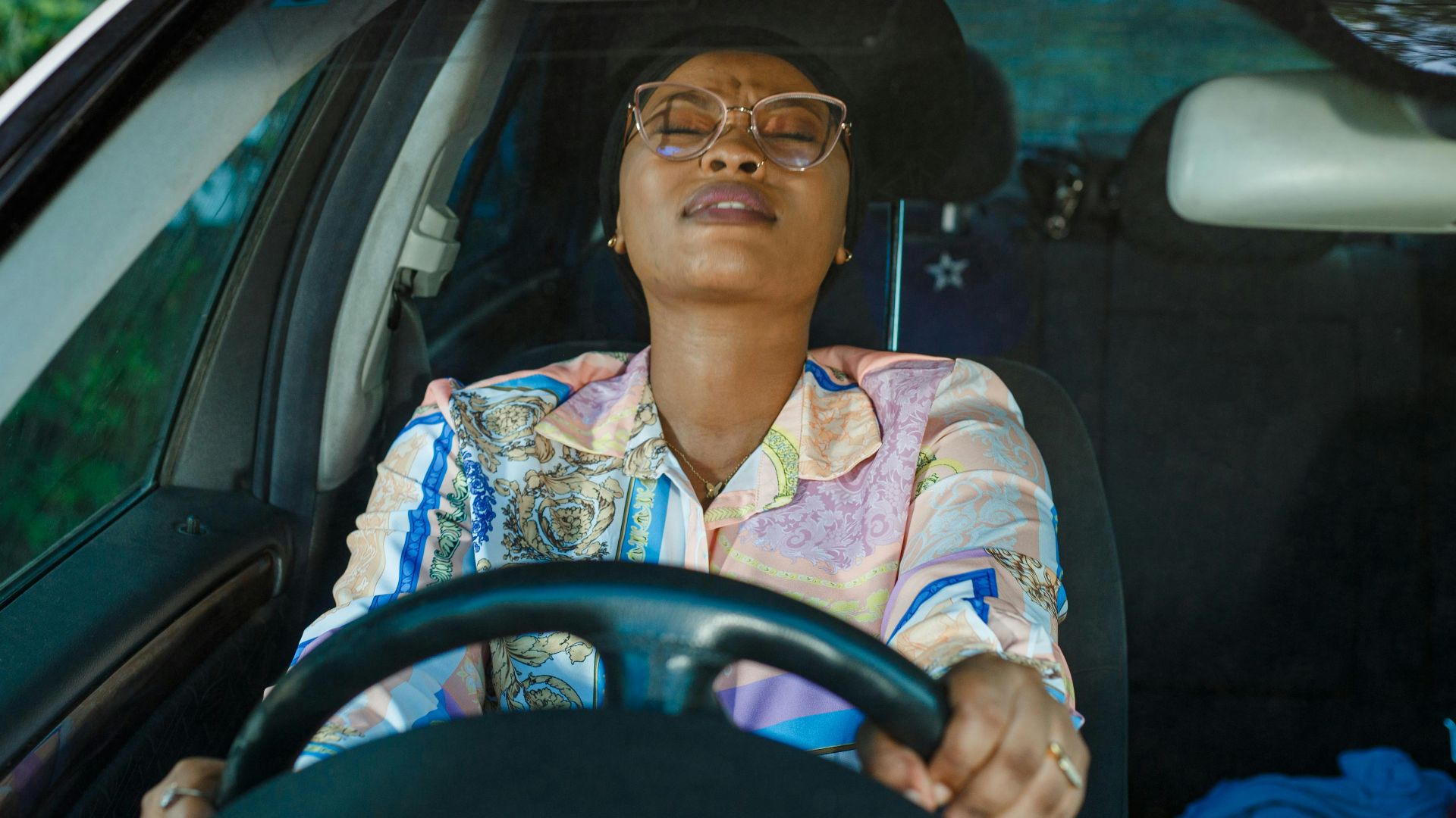 a woman sitting in the driver seat of a car