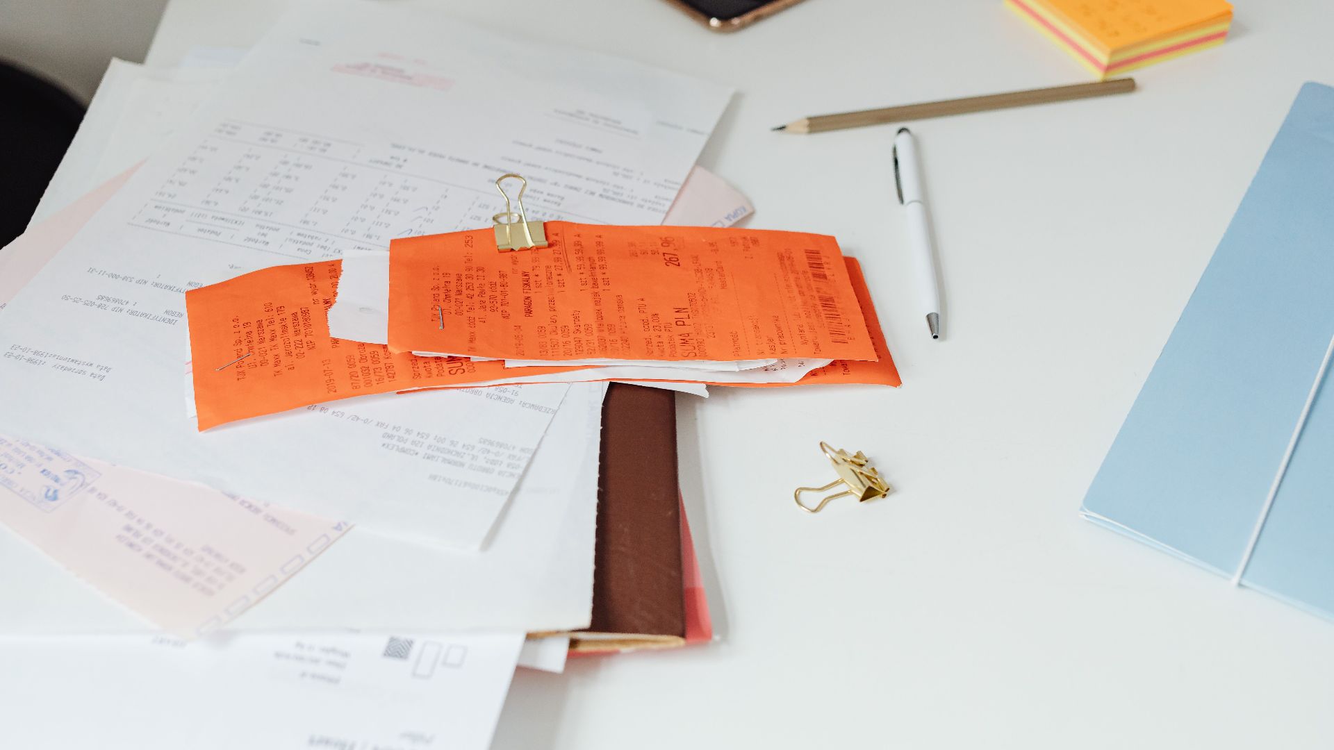 Close-up of a tidy desk with receipts, documents, and office stationery for business organization.