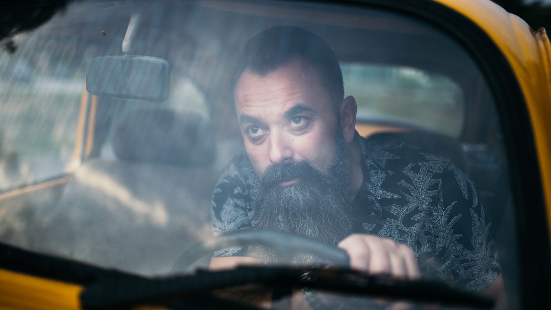 Bearded man in the car looking through the windshield