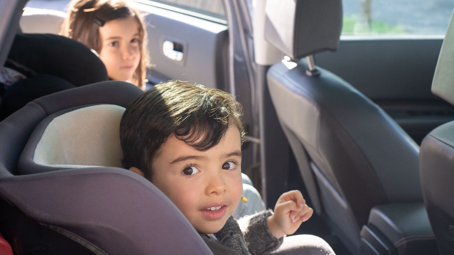 Two children sitting in a car, enjoying a family ride in Portugal.