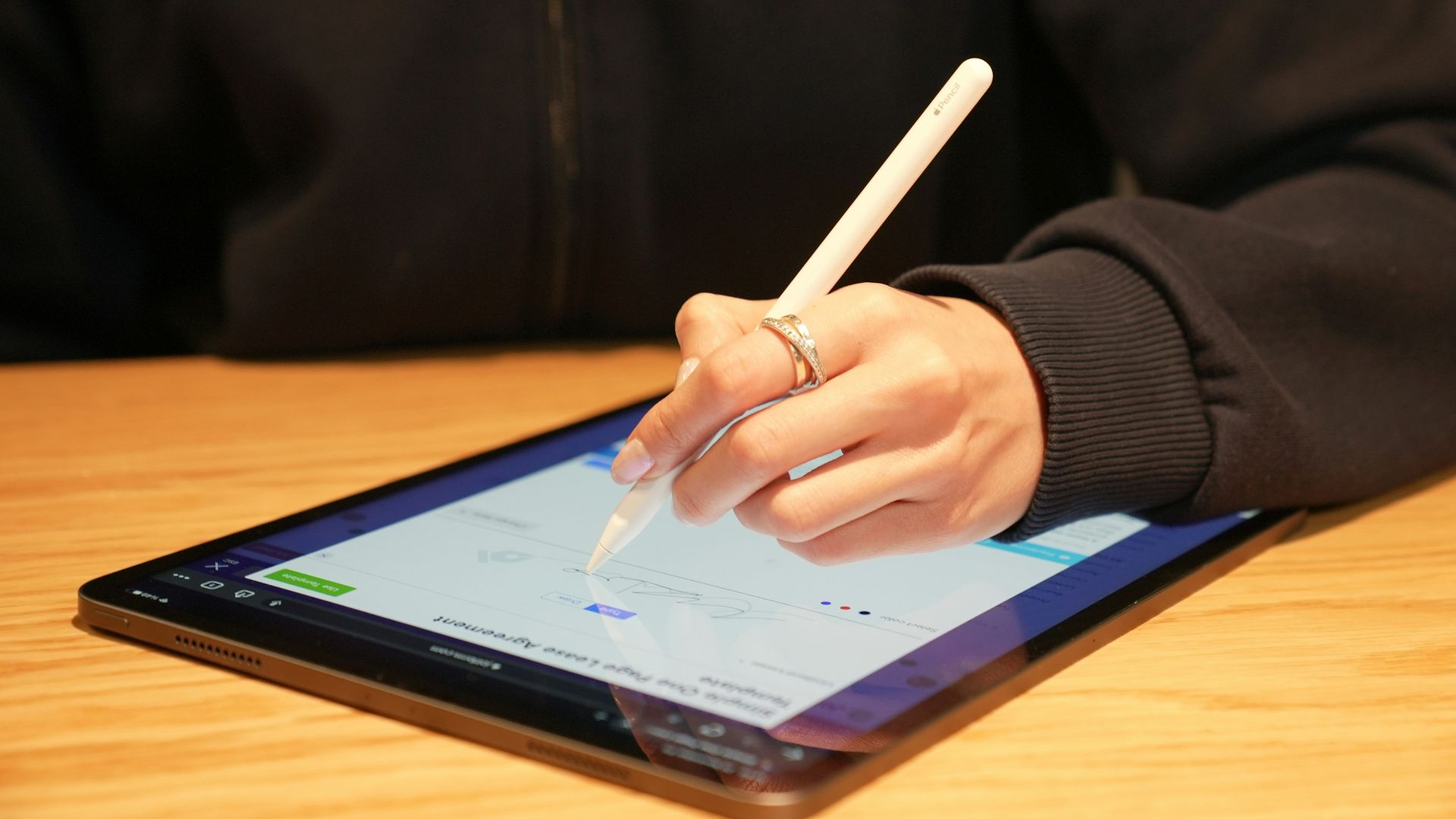 a person writing on a tablet with a pen