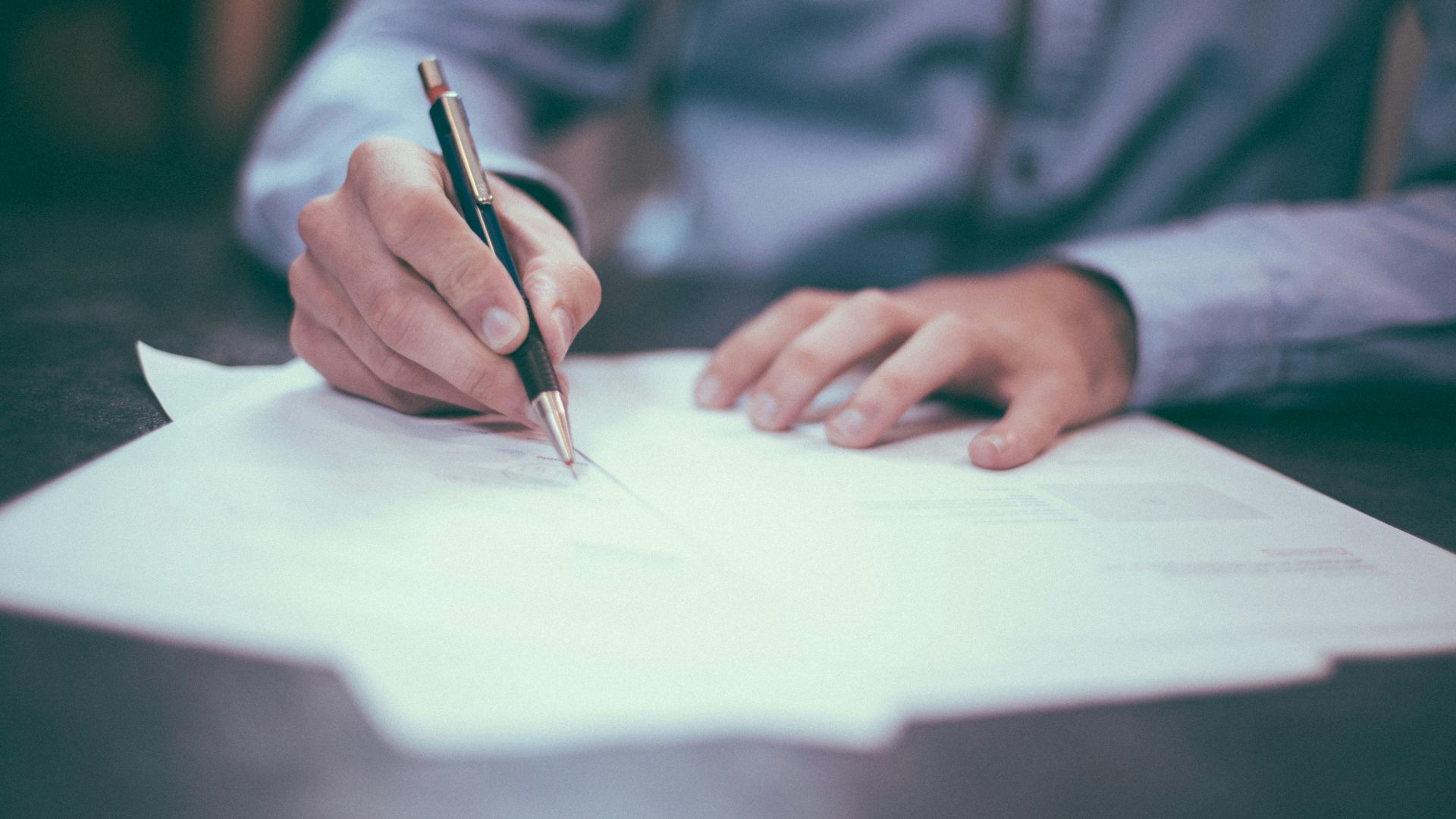 man writing on paper
