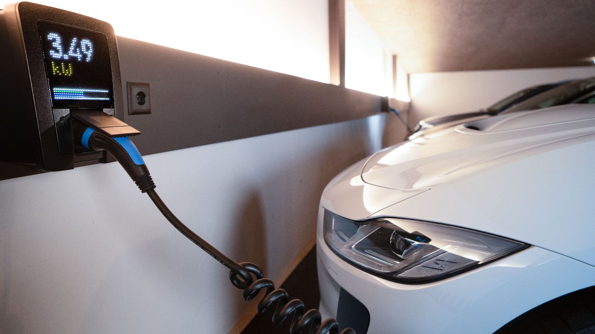 White electric car charging at indoor station, emphasizing sustainability and efficiency.