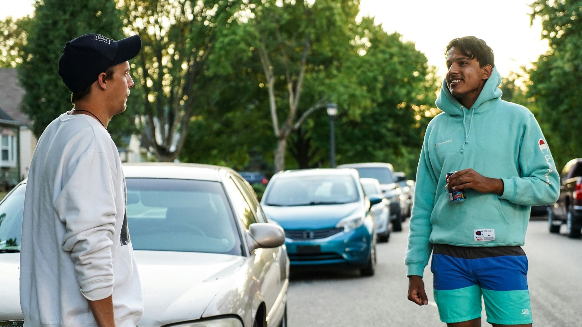 man in green hoodie standing on road during daytime