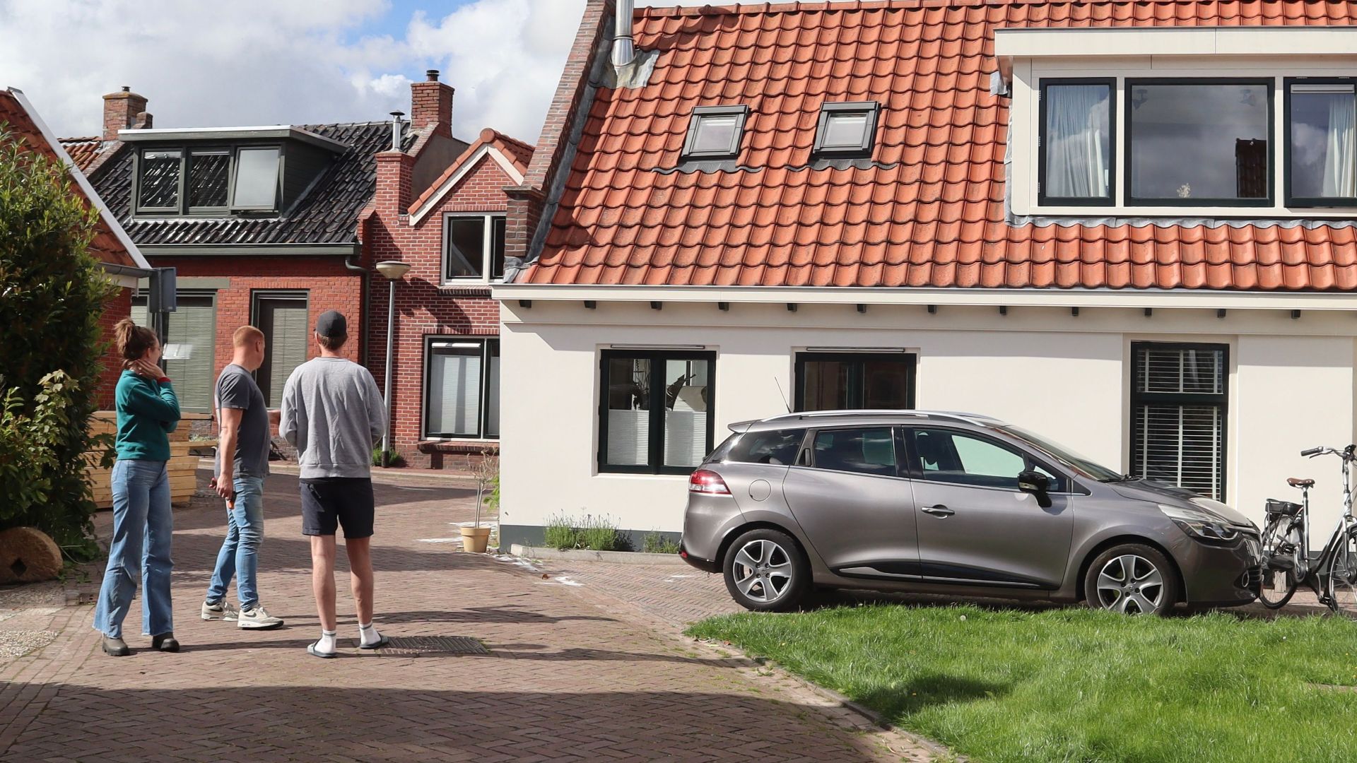 Charming view of traditional Dutch houses in Winsum, Netherlands with people standing outdoors.