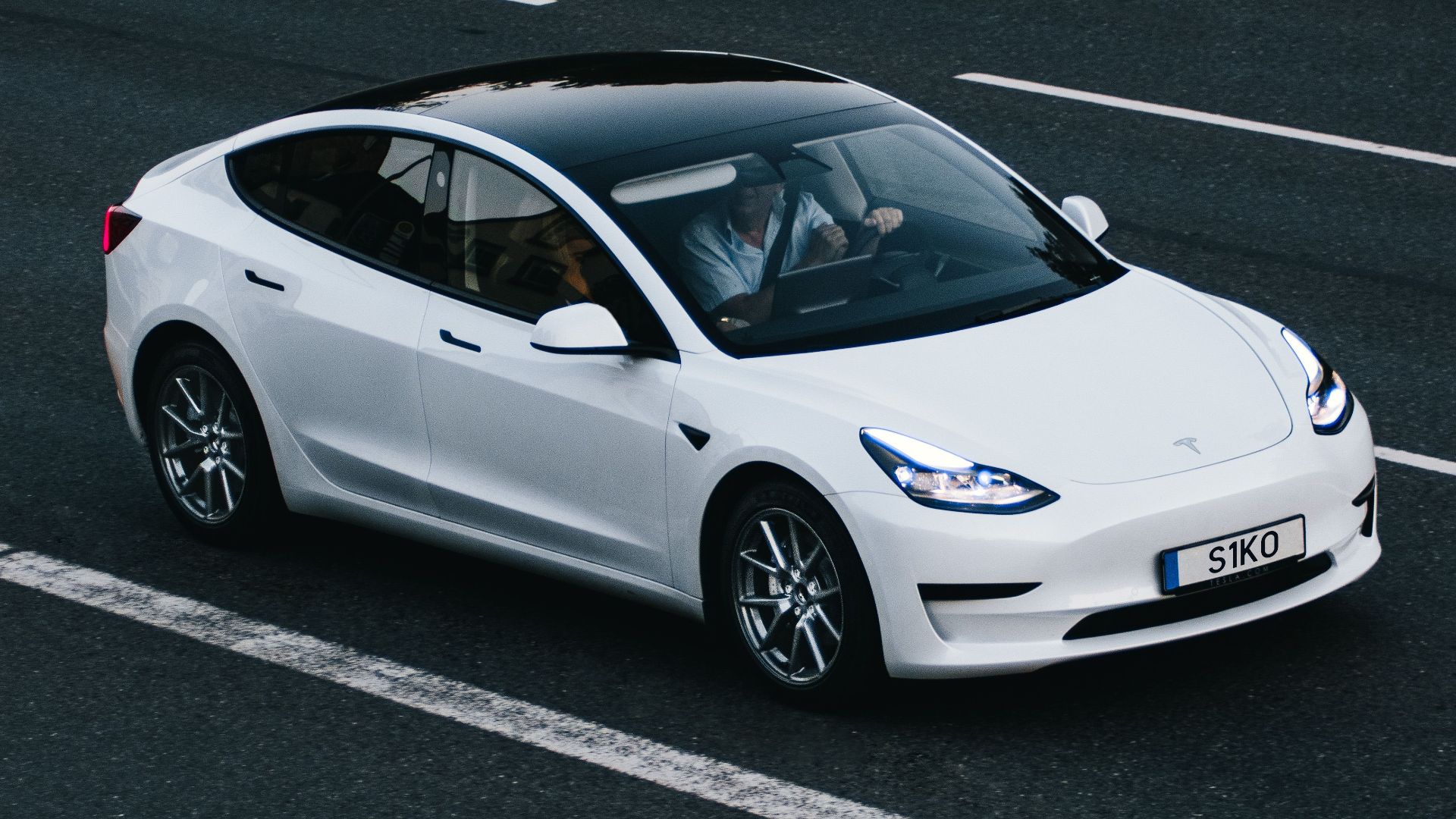 Tesla Model 3 driving on a highway in Osnabrück, Germany, showcasing modern electric vehicle design.