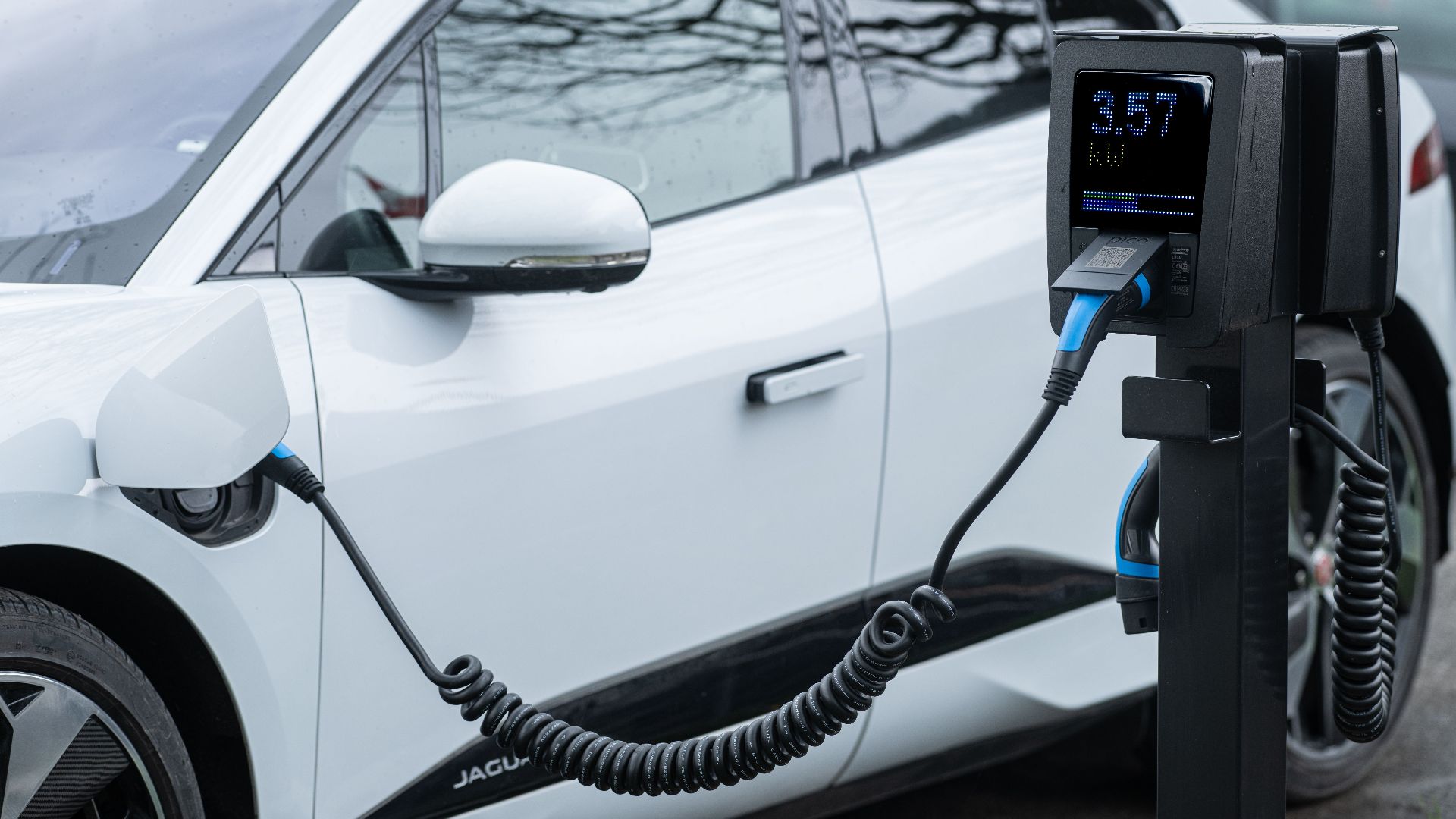 Close-up of an electric vehicle charging at a station, showcasing energy-efficient technology.