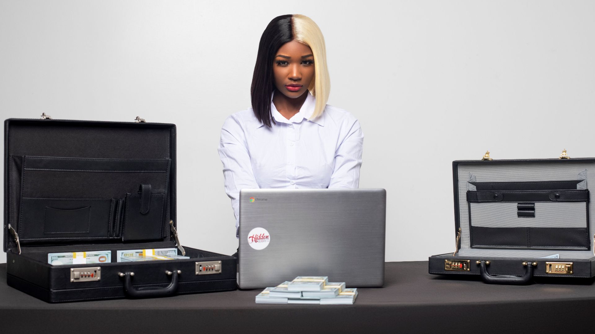 Confident businesswoman working at desk with briefcases and laptop, highlighting professionalism in Miami.