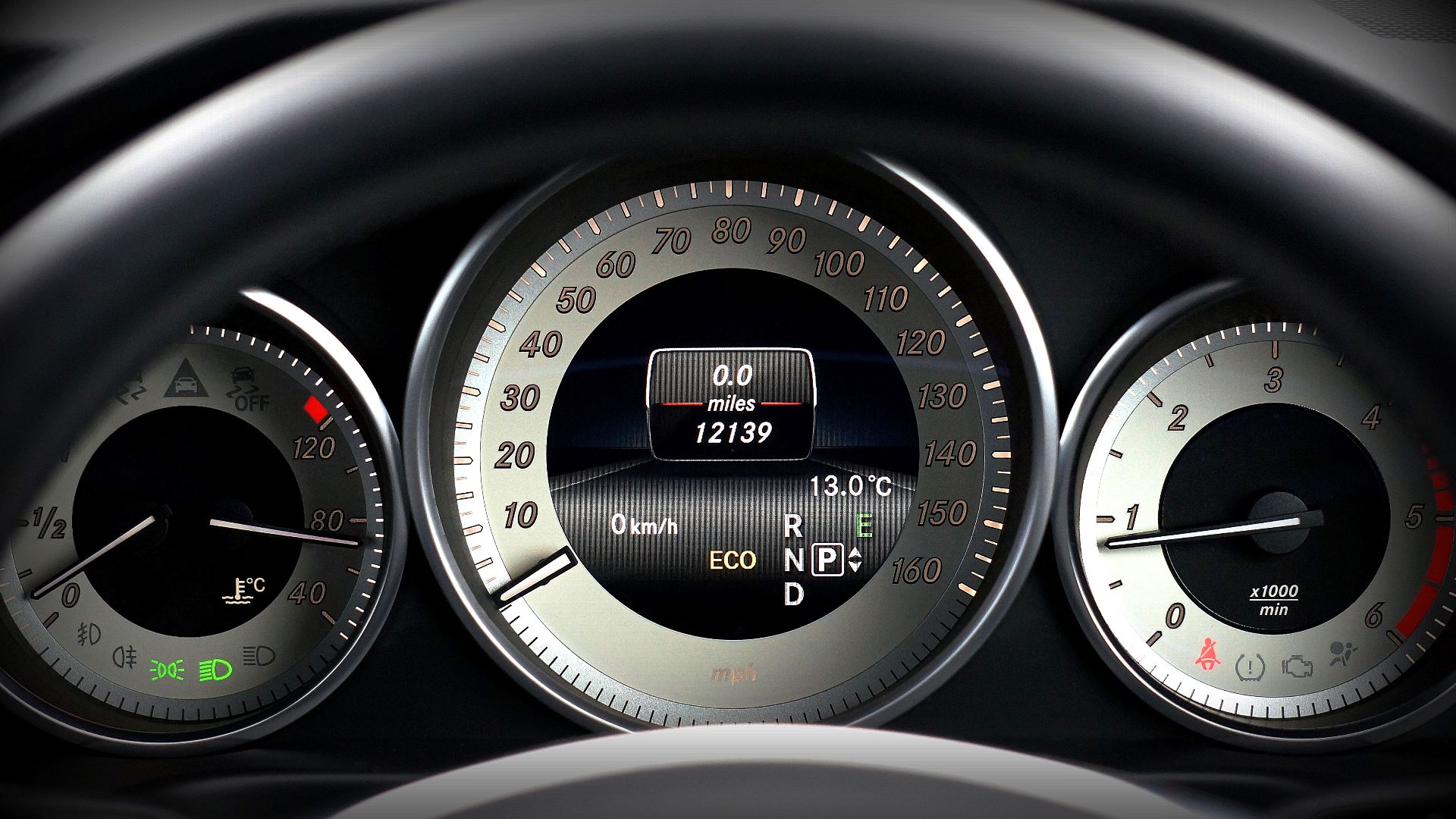Close-up image of a car dashboard highlighting speedometer, odometer, and temperature gauge.