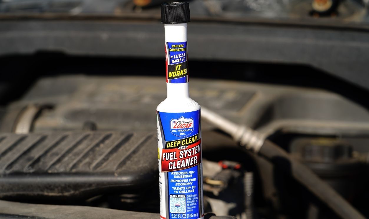 Fond du Lac, Wisconsin USA - February 24th, 2025: A bottle of Lucas Deep Clean Fuel System Cleaner sits on engine motor.