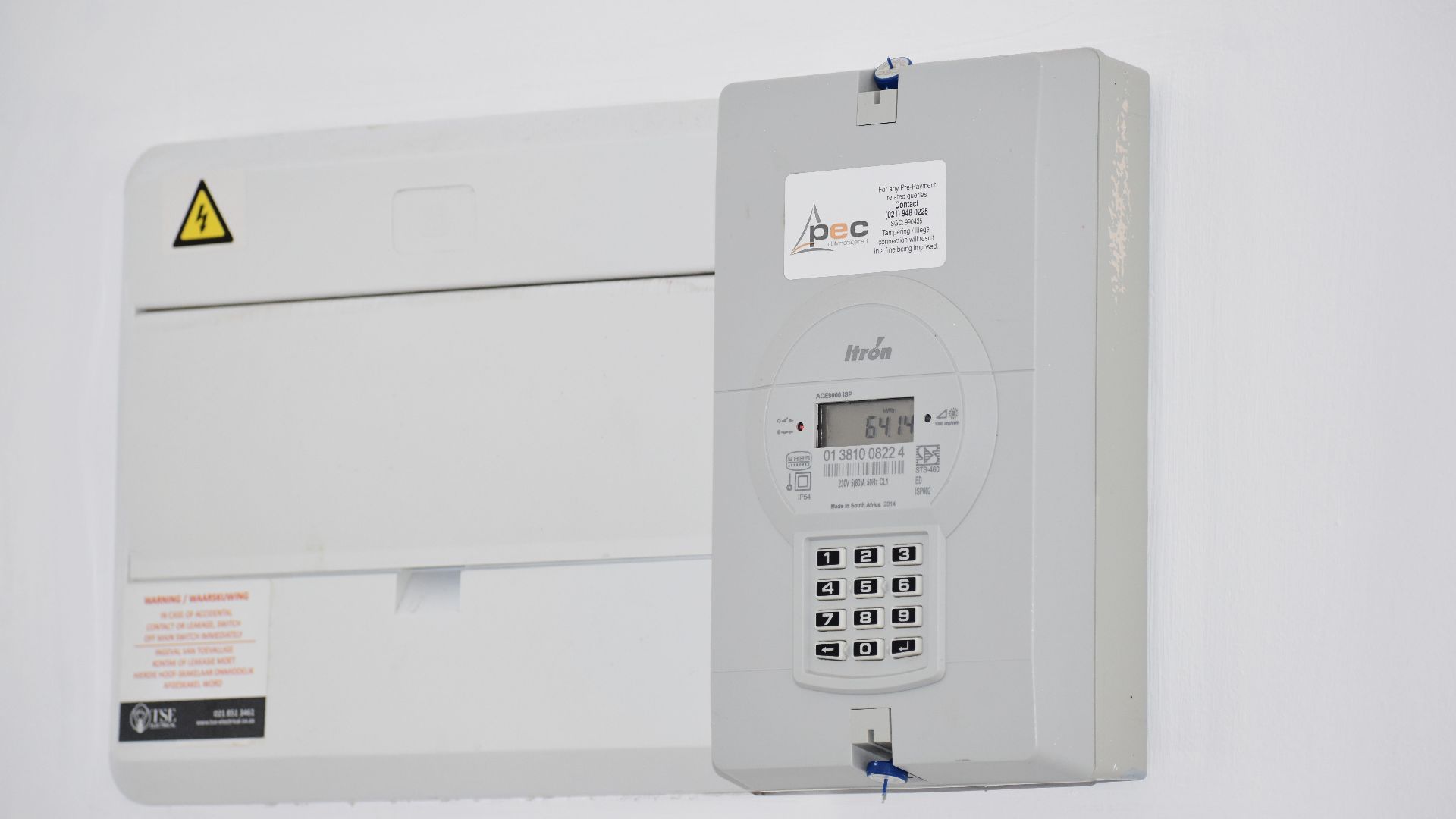Electrical meter and fuse box on a white wall in Cape Town, South Africa, for energy monitoring or billing.