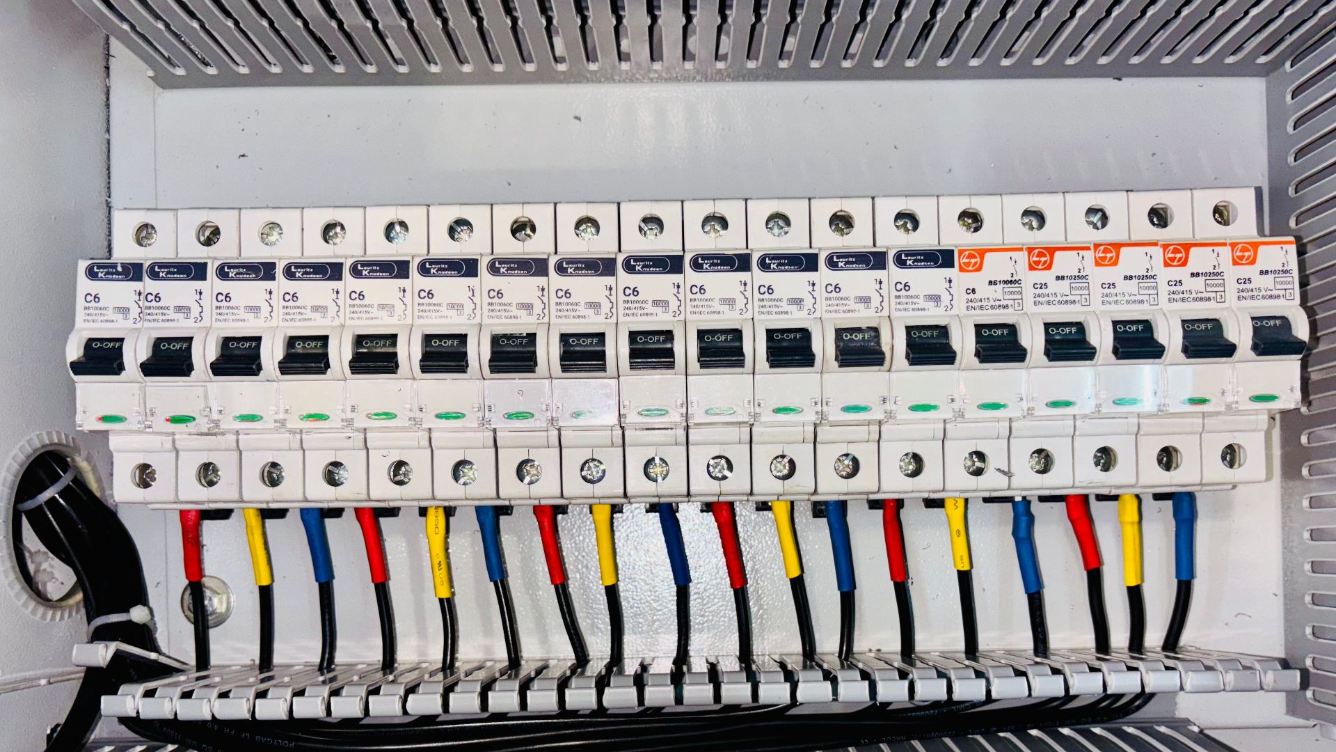 Close-up of an organized circuit breaker panel featuring color-coded electrical wiring.