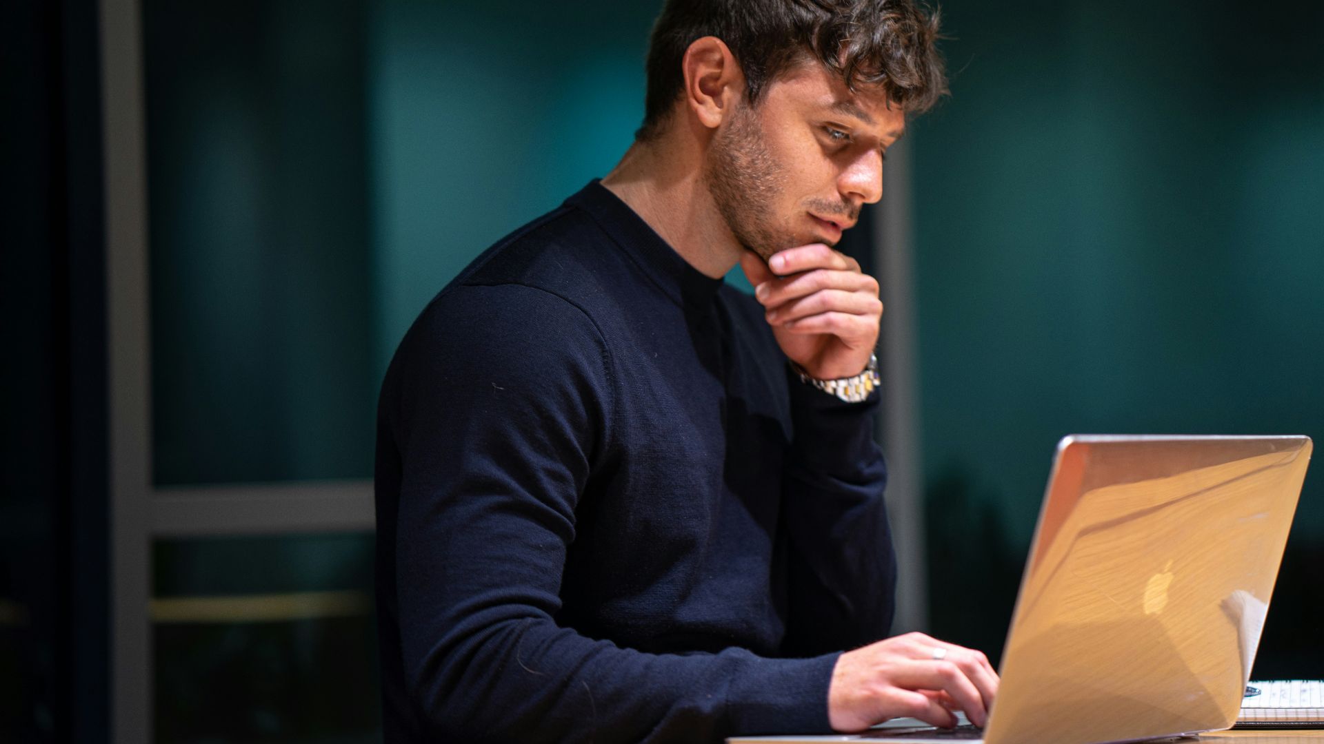 man in black long sleeve shirt sitting in front of macbook