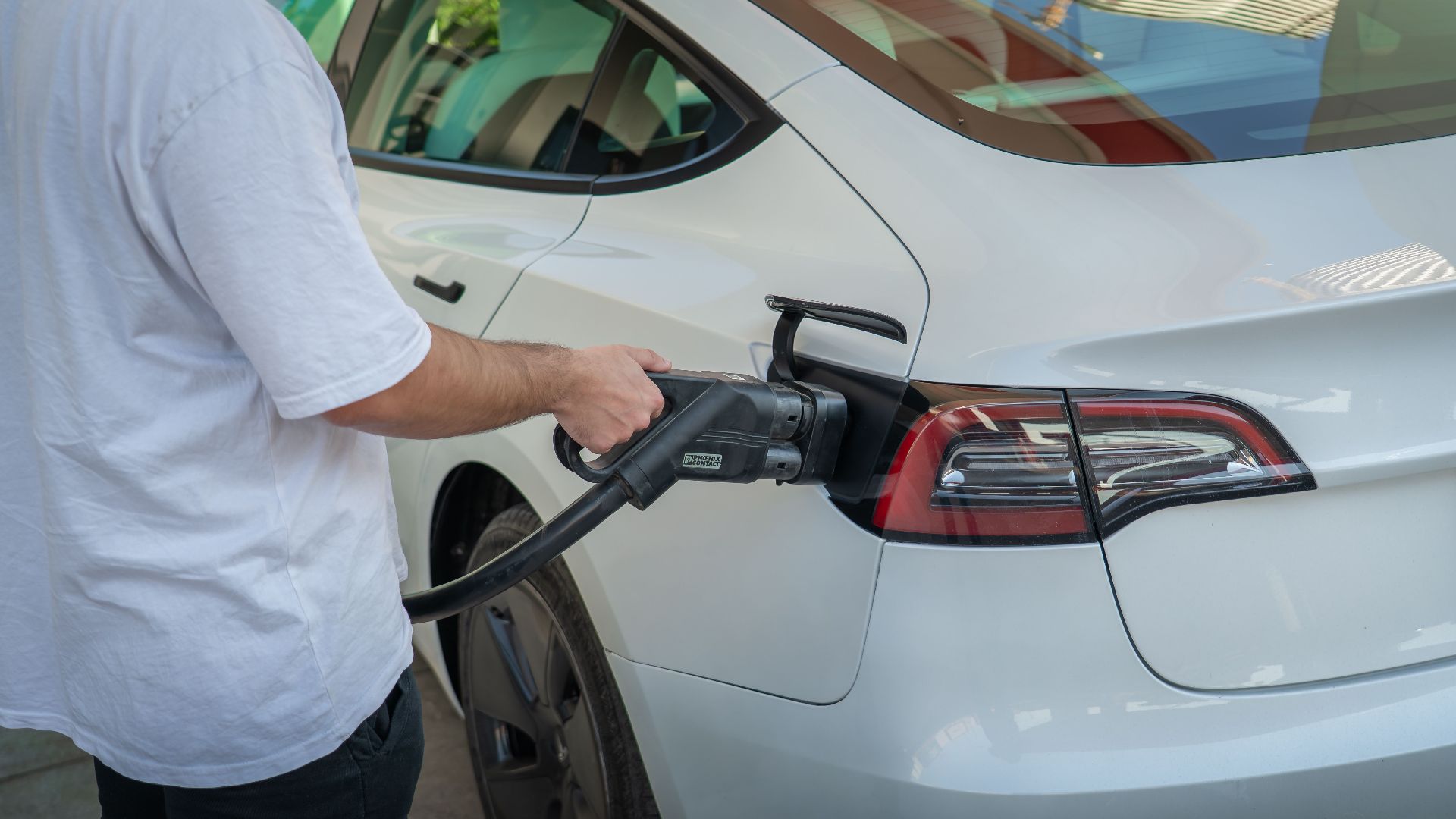 Electric car being charged at a station, highlighting eco-friendly transportation.