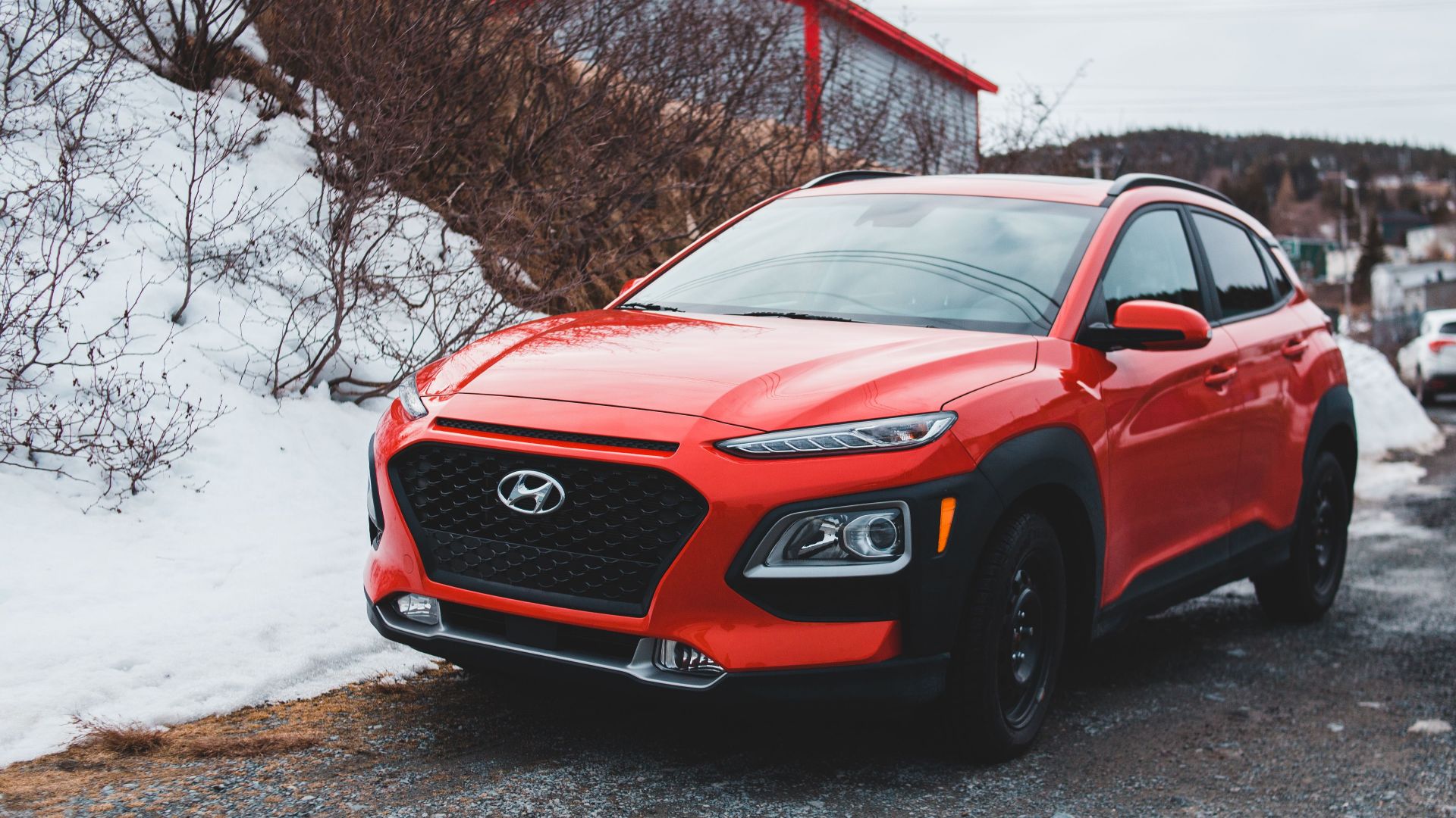 A red Hyundai SUV parked outdoors on a snowy day, showcasing modern design and style.