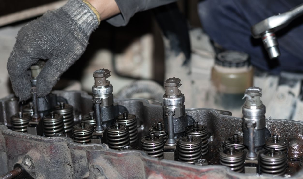 The mechanic is checking the engine.