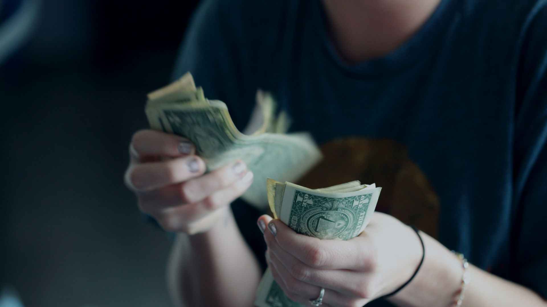 focus photography of person counting dollar banknotes