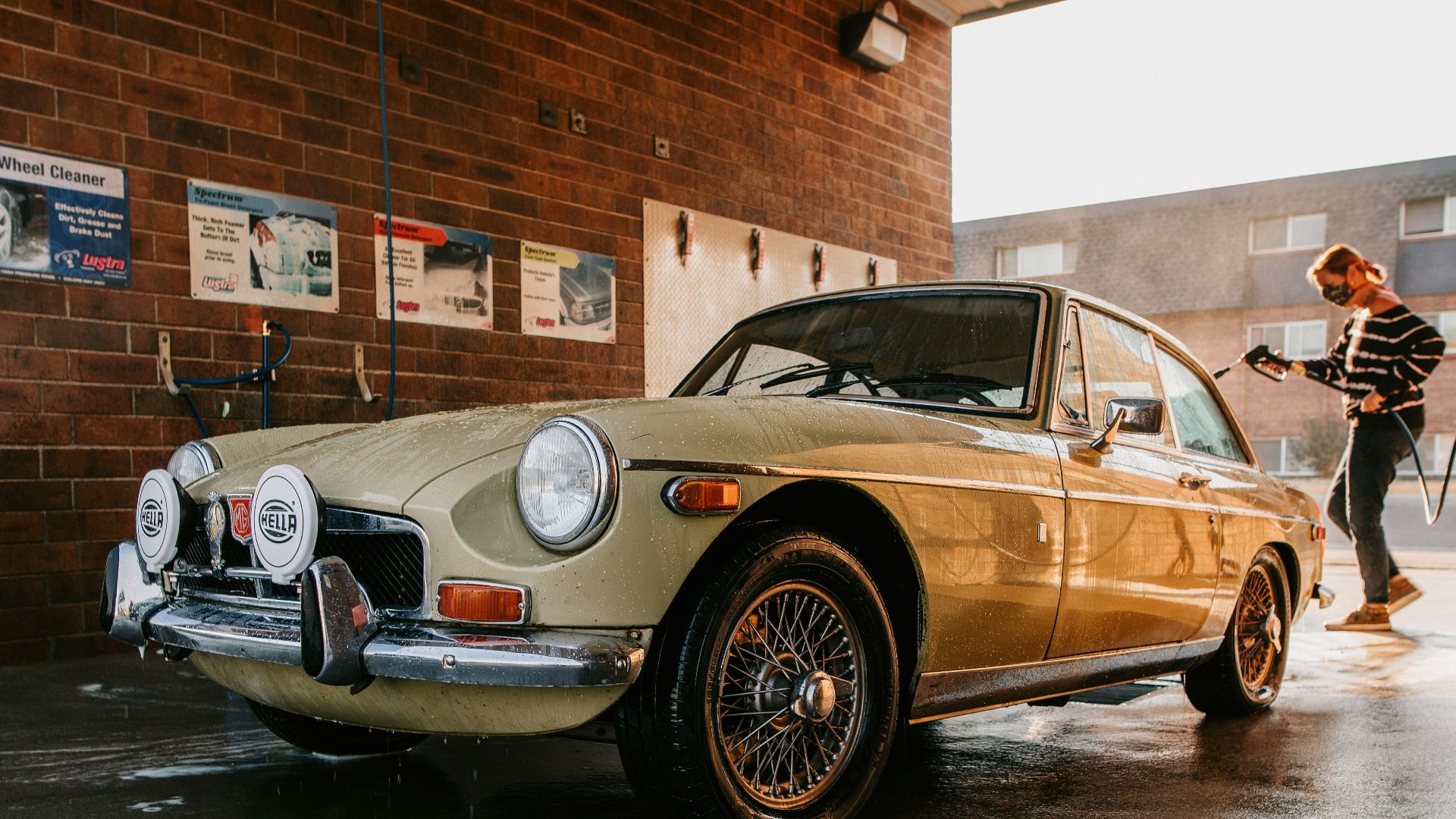 a woman standing next to a tan car