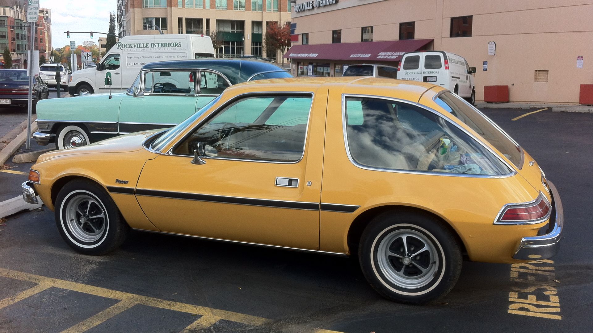 1975 AMC Pacer coupe, built by American Motors Corporation, left side view. Picture taken while parked off West Middle Lane in Rockville, Maryland, with a Packard 400 two-door hardtop in the background, at the Apollo Restaurant (12 North Washington Street